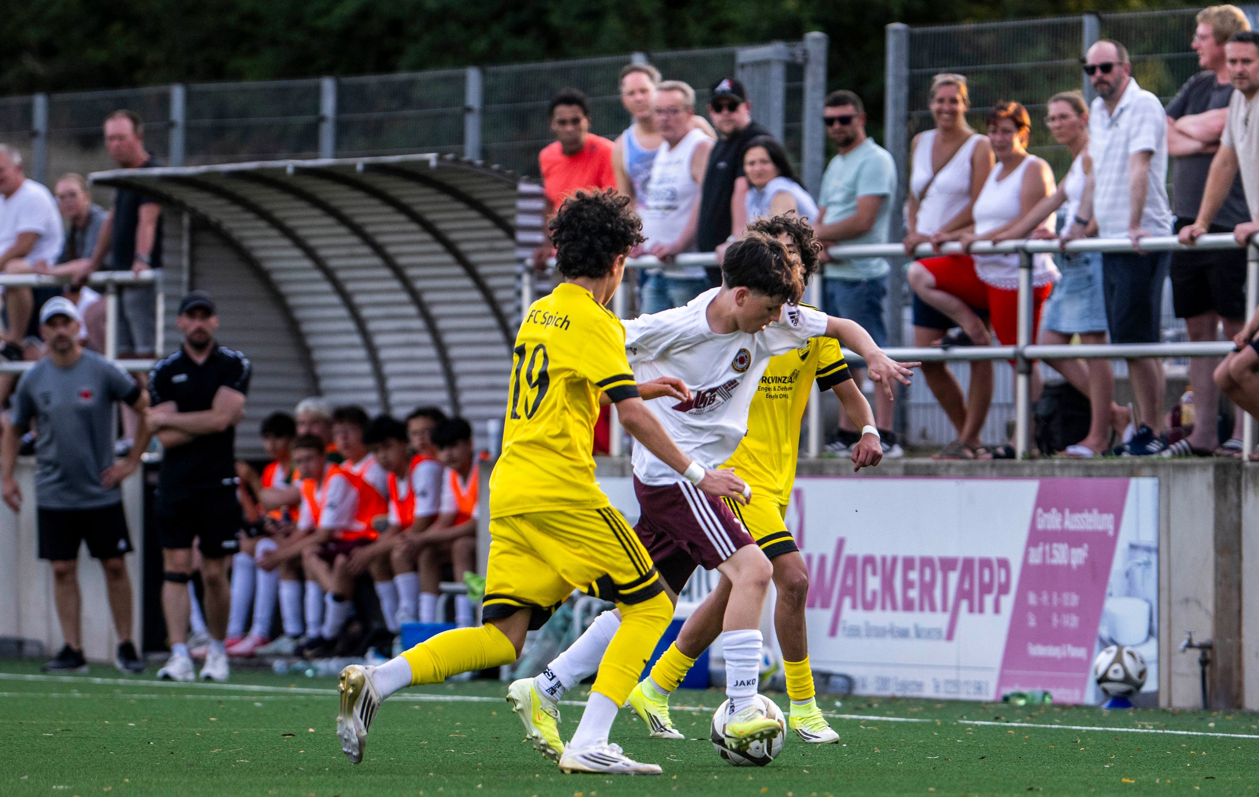 Ein Spieler des SSV Lommersum dribbelt gegen zwei Gegenspieler.