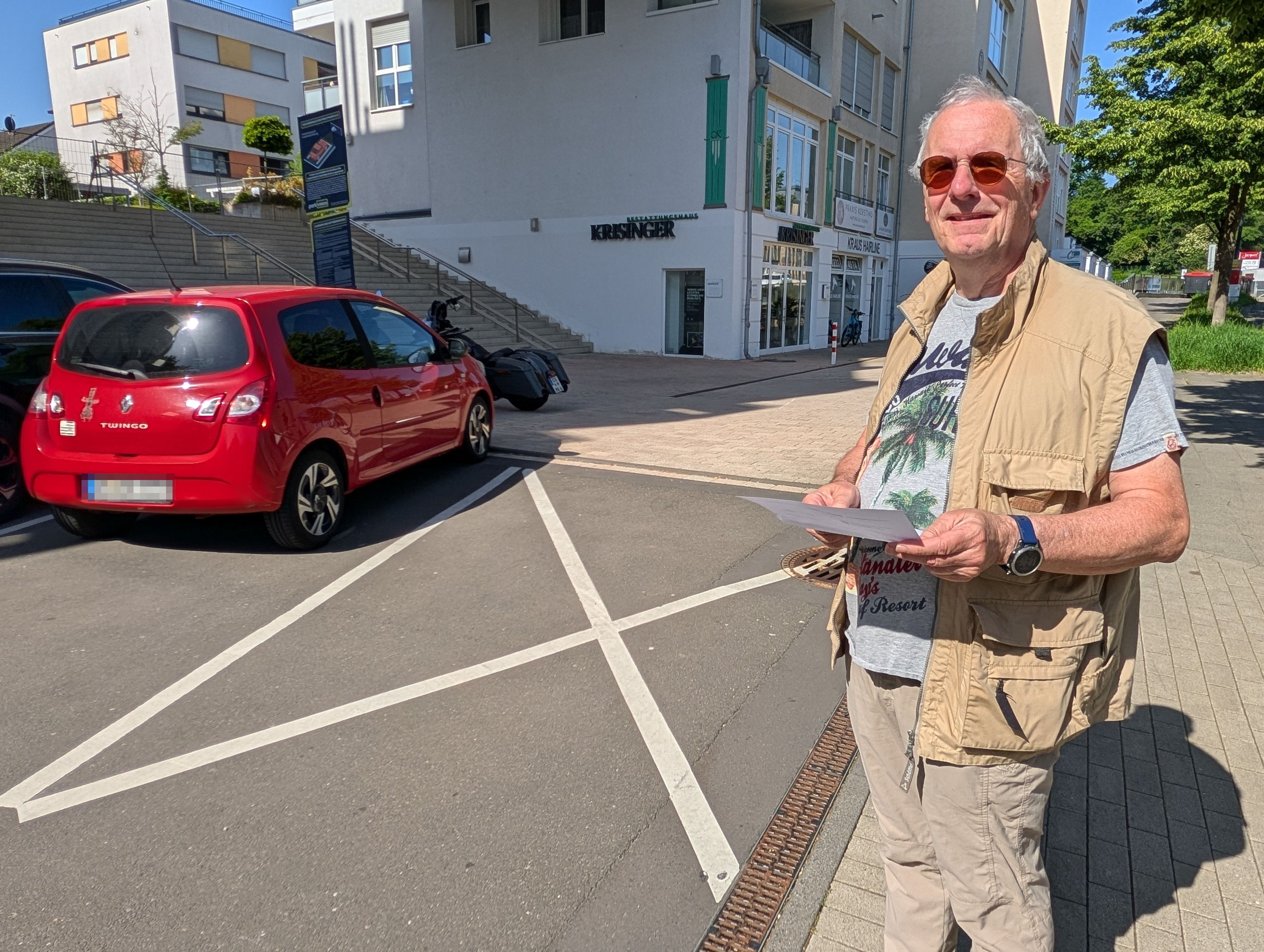 Das Foto zeigt den Hürther mit der Zahlungsaufforderung vor der markierten Sperrfläche.