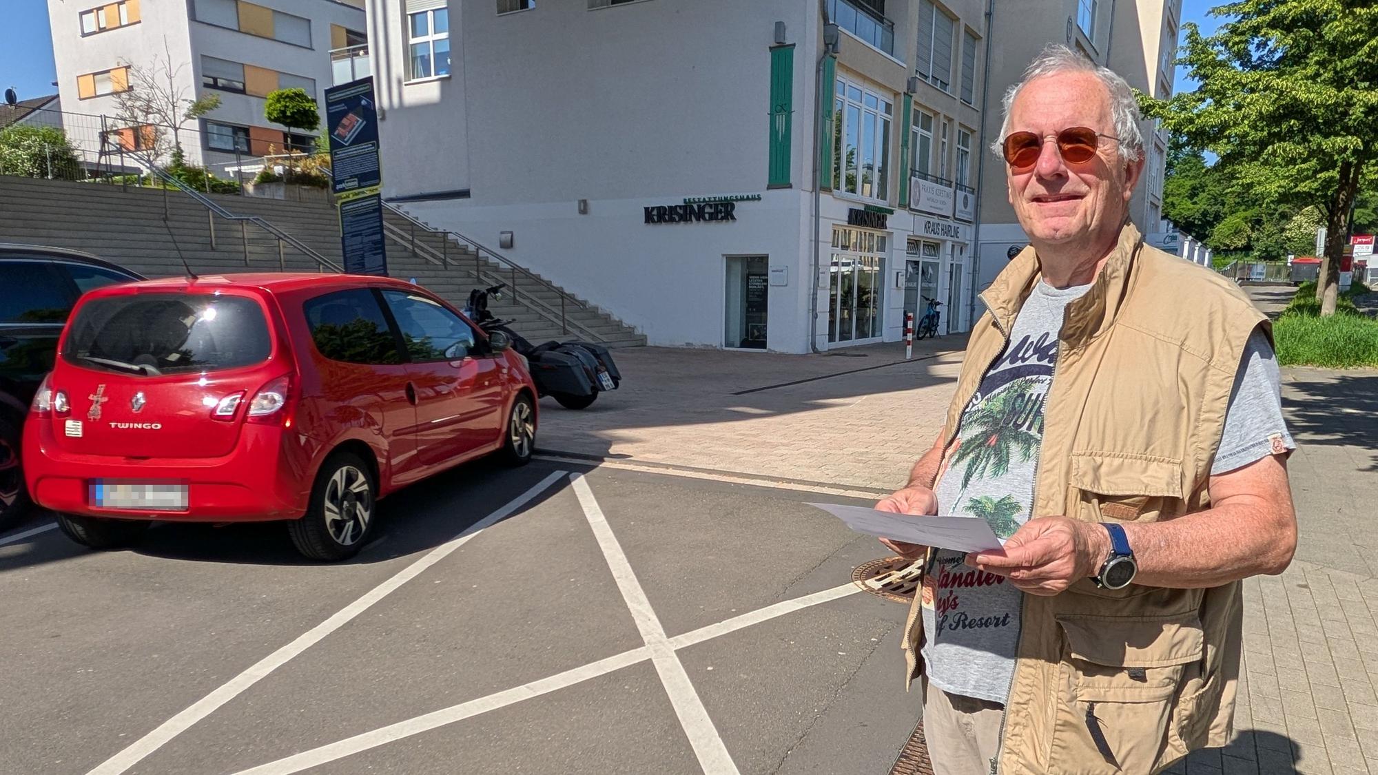 Das Foto zeigt den Hürther mit der Zahlungsaufforderung vor der markierten Sperrfläche.