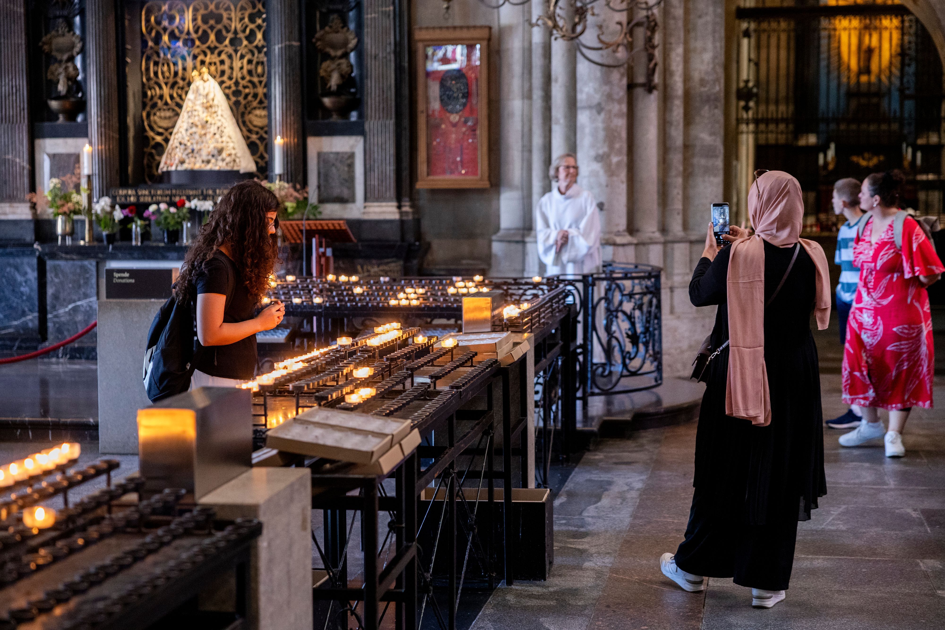 Eine Frau (r.) fotografiert die Schmuckmadonna im Kölner Dom.