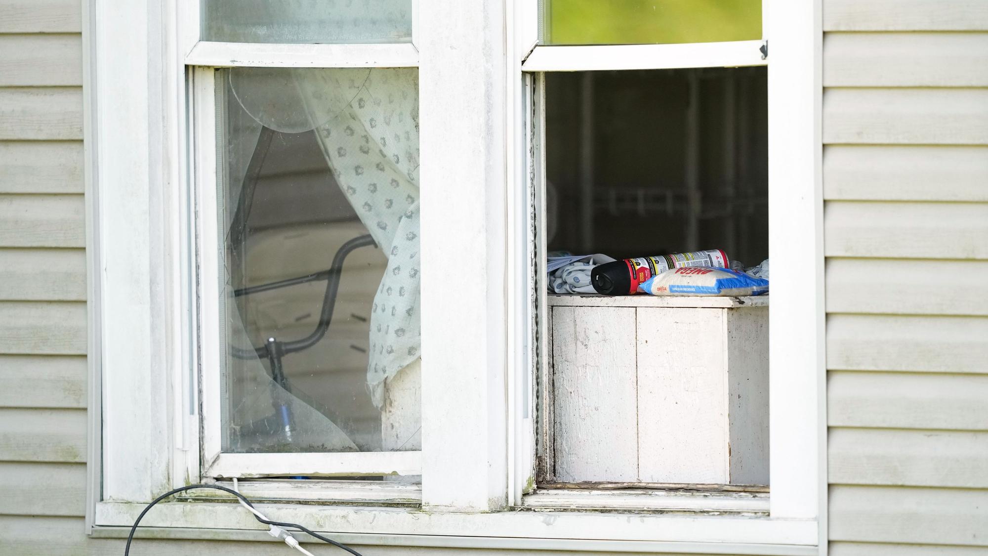 Ein Sack Reis und eine Dose Insektizid stehen in einem offenen Fenster eines Hauses, aus dem die Behörden nach eigenen Angaben 16 Kinder in Obhut genommen und vier Erwachsene festgenommen haben.