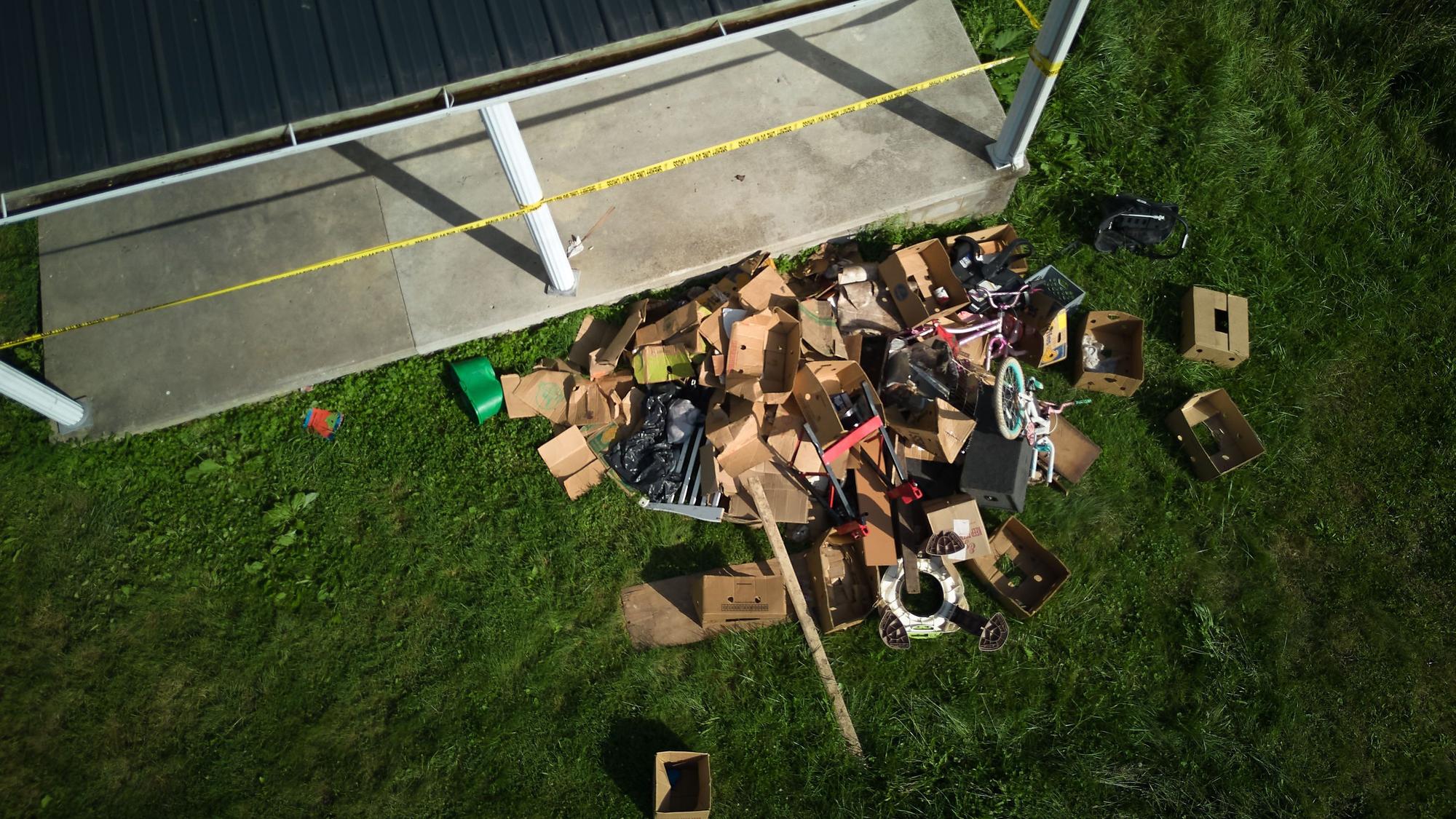 In dem Vorgarten eines Hauses, aus dem die Behörden nach eigenen Angaben 16 Kinder in Sicherheit gebracht und vier Erwachsene festgenommen haben, liegt Unrat.