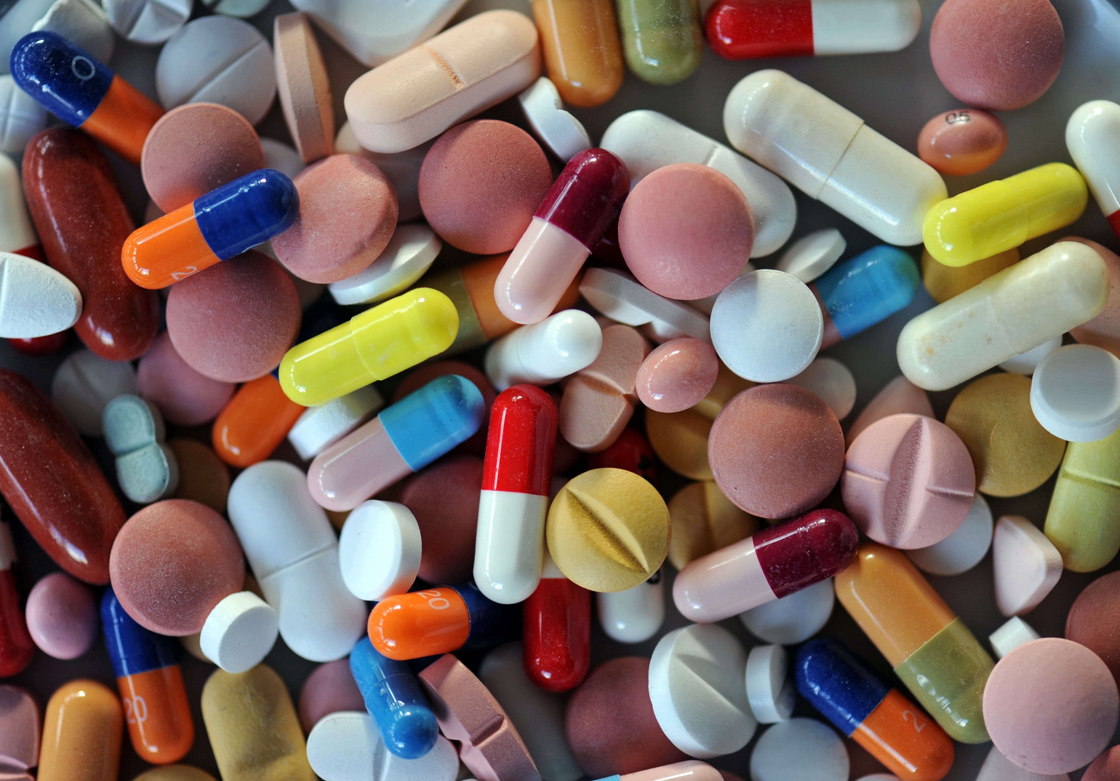 Verschiedene Pillen und Tabletten liegen auf einem Teller.