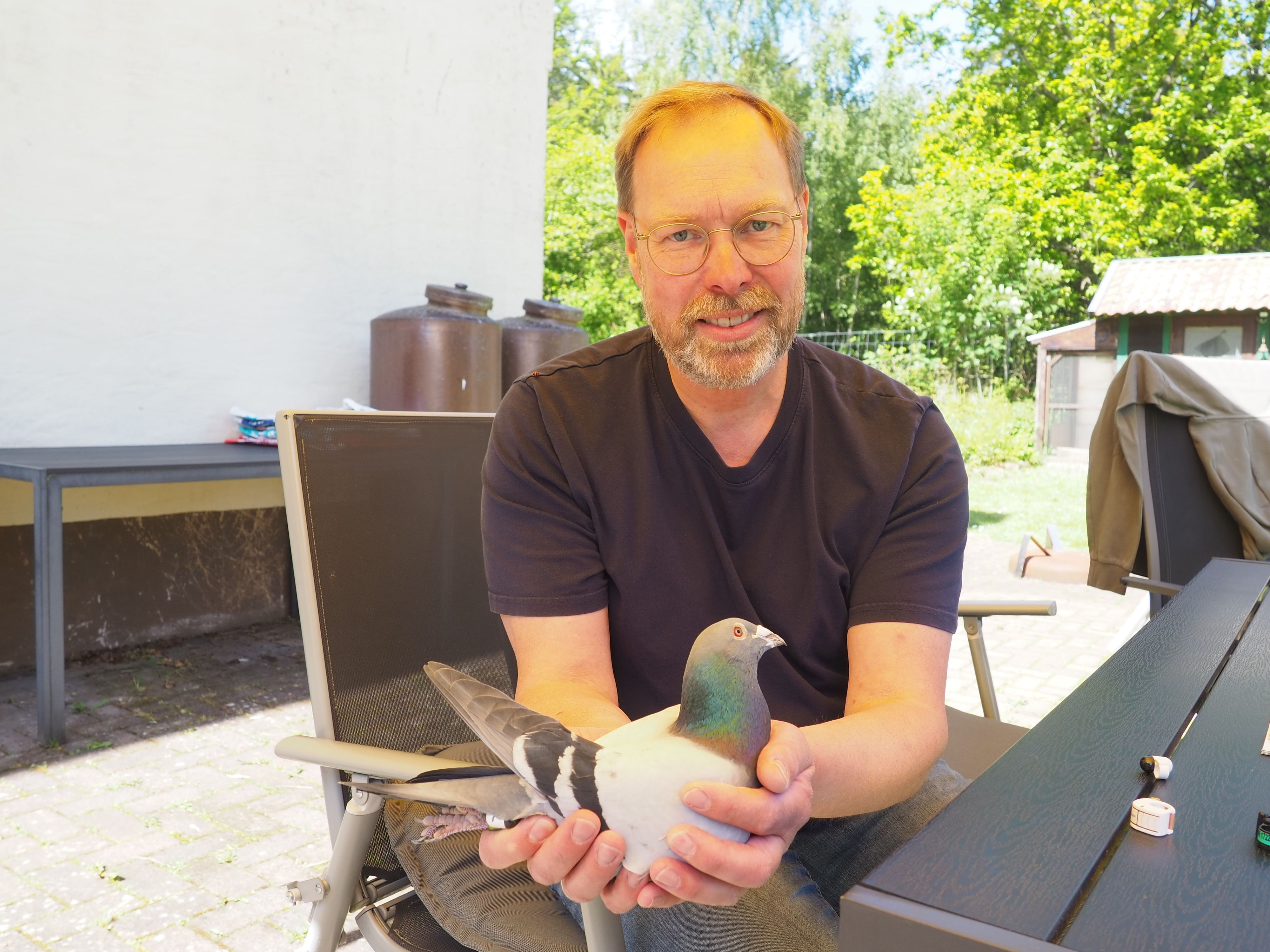 Ein Mann hält eine Taube in den Händen.