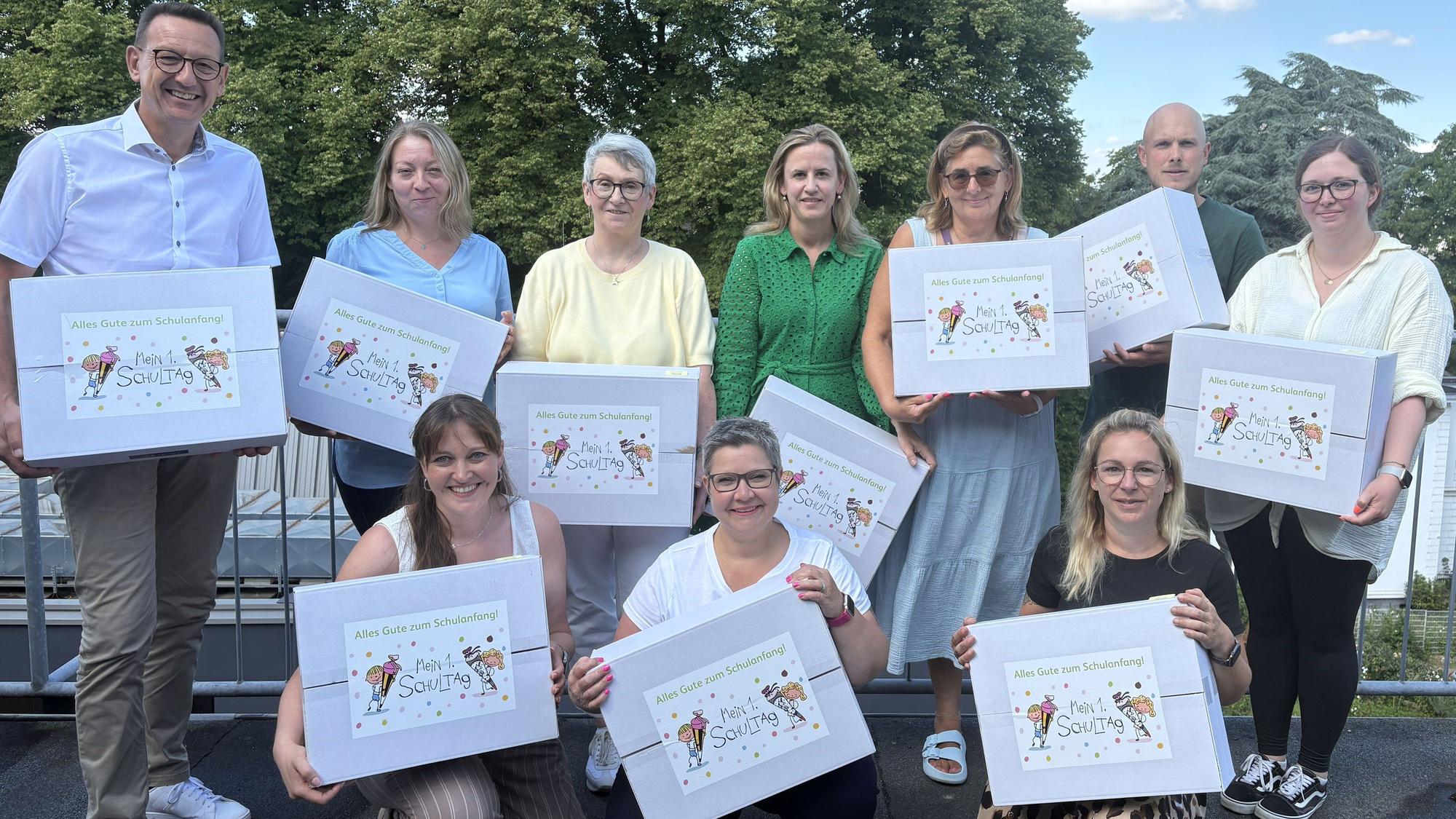 Bürgermeister Dirk Runge (hinten, v.l.), Sandra Osbringhaus, Edelgard Reininghaus, Annika Wiertz (Adient), Elke Lojen, Julian Mihm, Karen Buamgartner-Martin sowie Sabrina Werner (vorne, v.l.), Sandra Mundt und Frauke Alexander freuen sich, wieder einkommensschwache Familien zum Schulstart entlasten zu können.