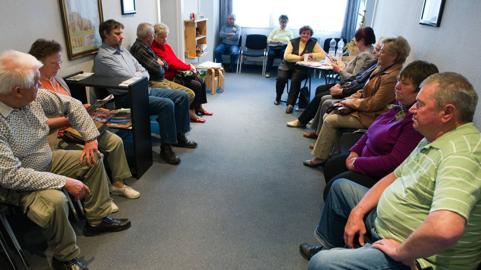 Viele Patienten sitzen einem Wartezimmer einer Arztpraxis.