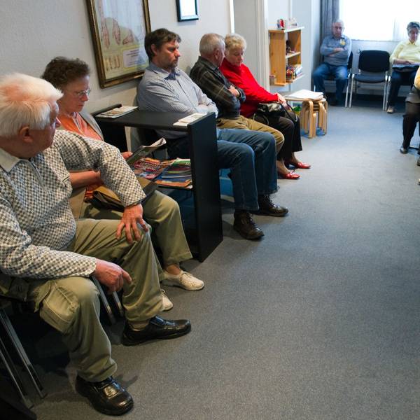 Viele Patienten sitzen einem Wartezimmer einer Arztpraxis.