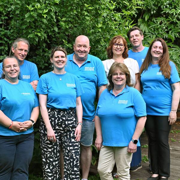 Gruppenfoto der Teammitglieder, die blaue T-Shirts der Diakonie tragen.