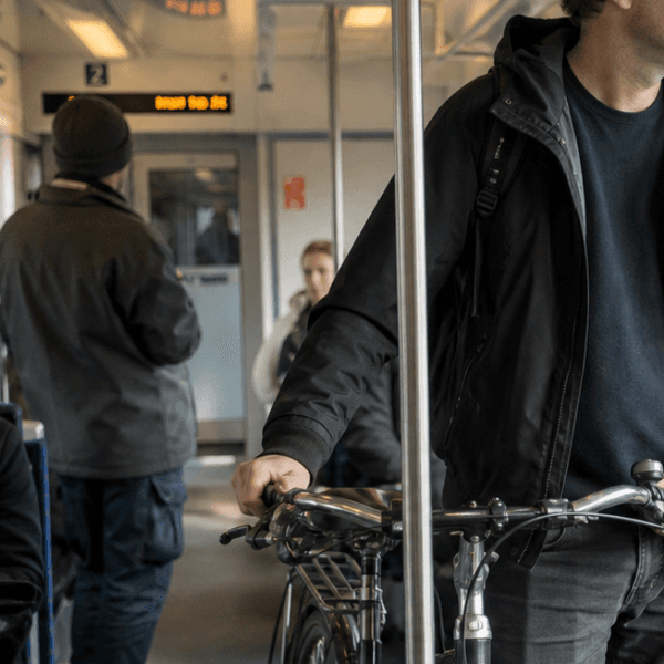 Ein Mann der mit seinem Fahrrad in der Bahn fährt.