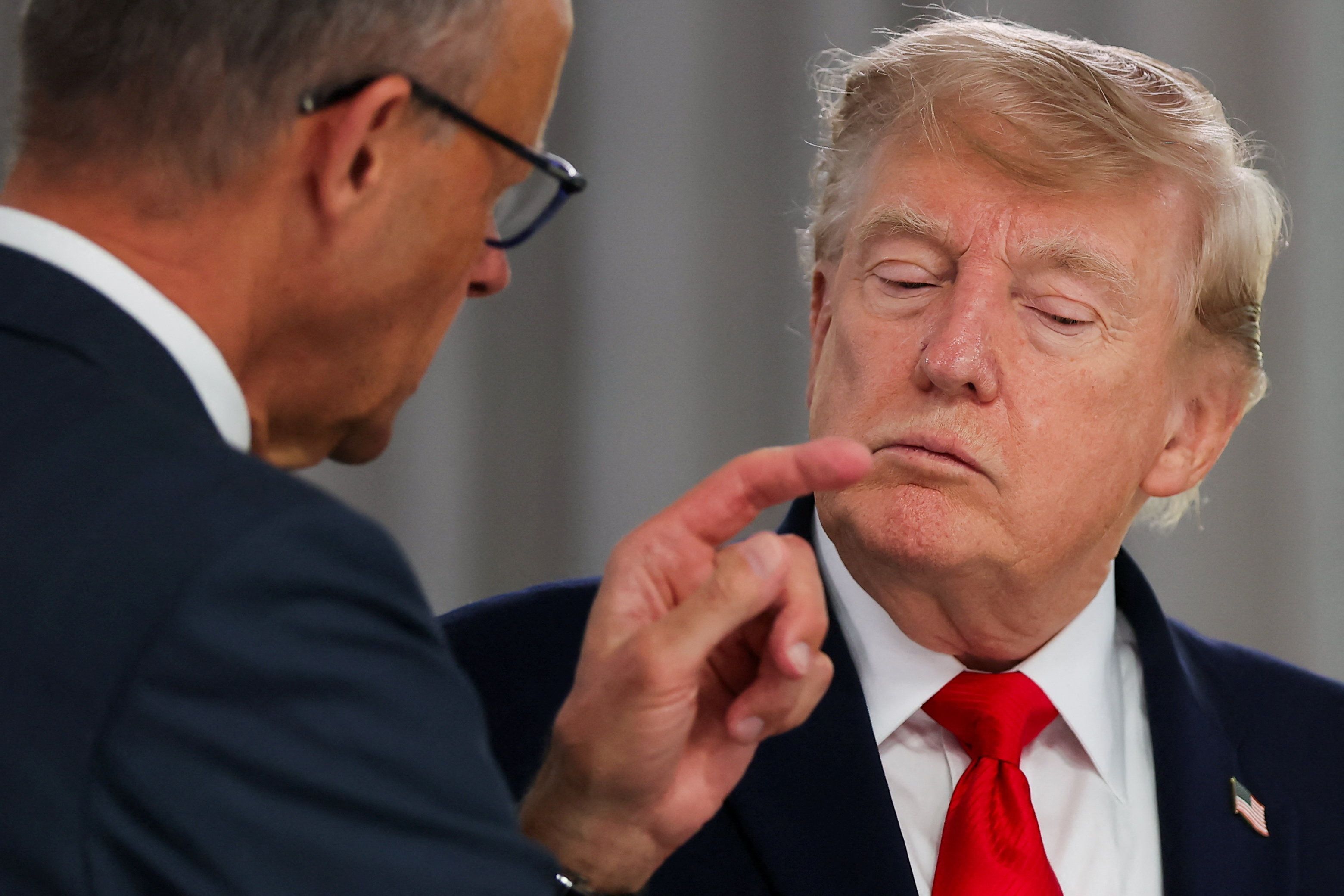 US-Präsident Donald Trump hört dem deutschen Bundeskanzler Friedrich Merz (l) bei einem Arbeitsessen mit den Staats- und Regierungschefs der G7 und des Nahen Ostens zu.