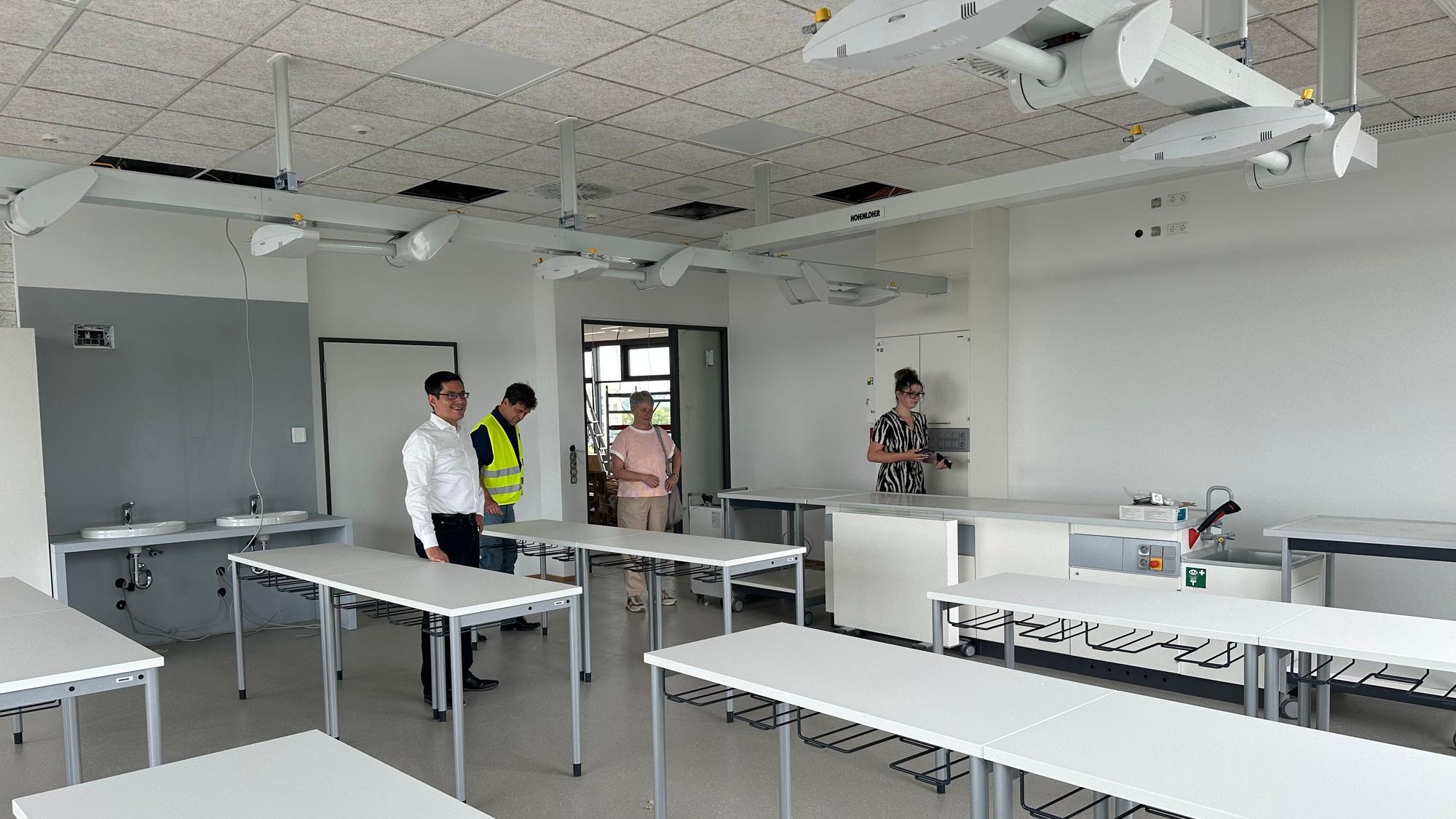Blick in einen Klassenraum für Naturwissenschaften. Die Gasversorgung für Bunsenbrenner kommt von den Versorgungsmodulen an der Decke.