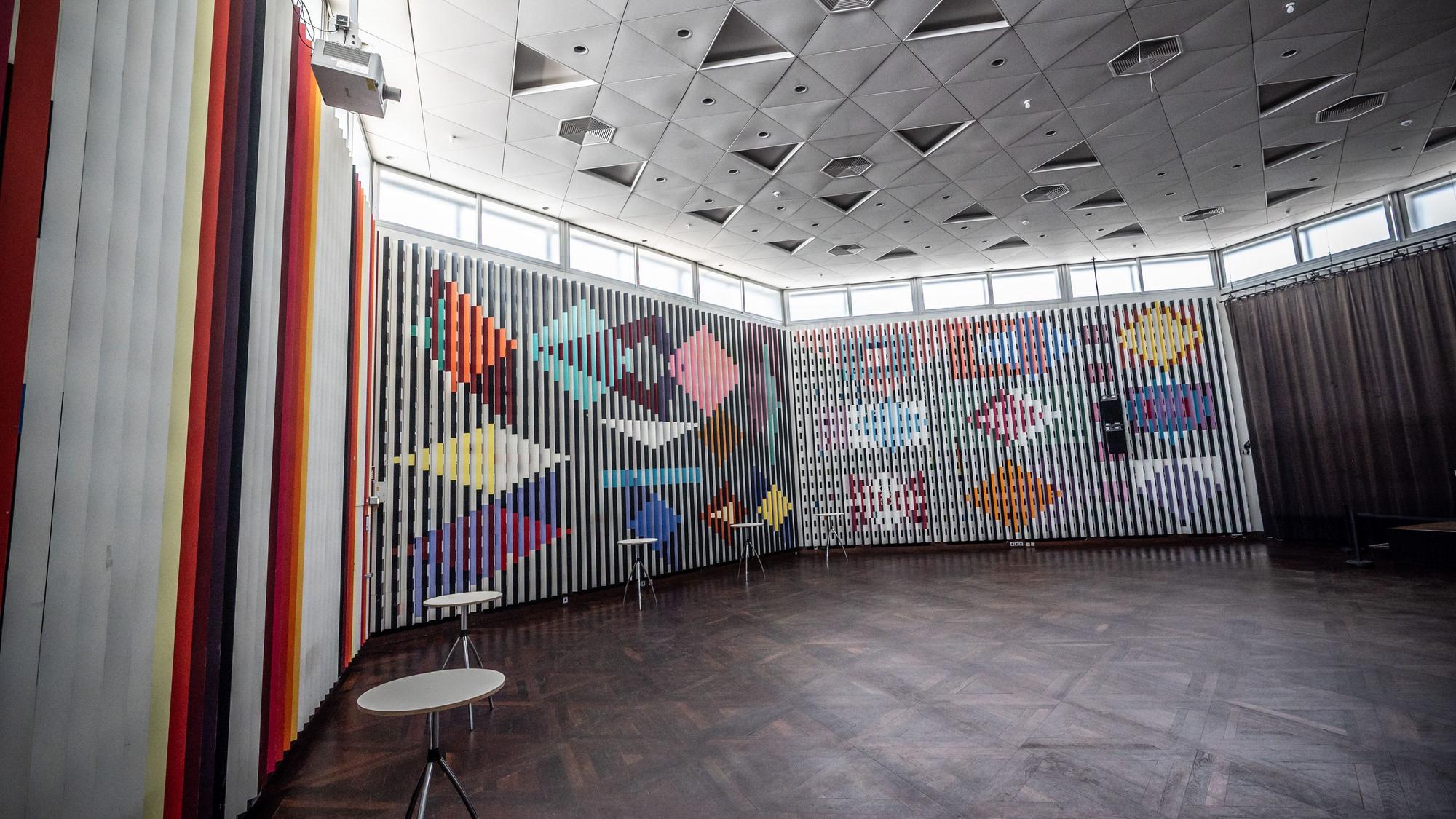 Der Agamsaal im Forum wurde im Jahr 1969 und 1970 gestaltet. Xaacov oder Yaʿacov Agam starb 2026.