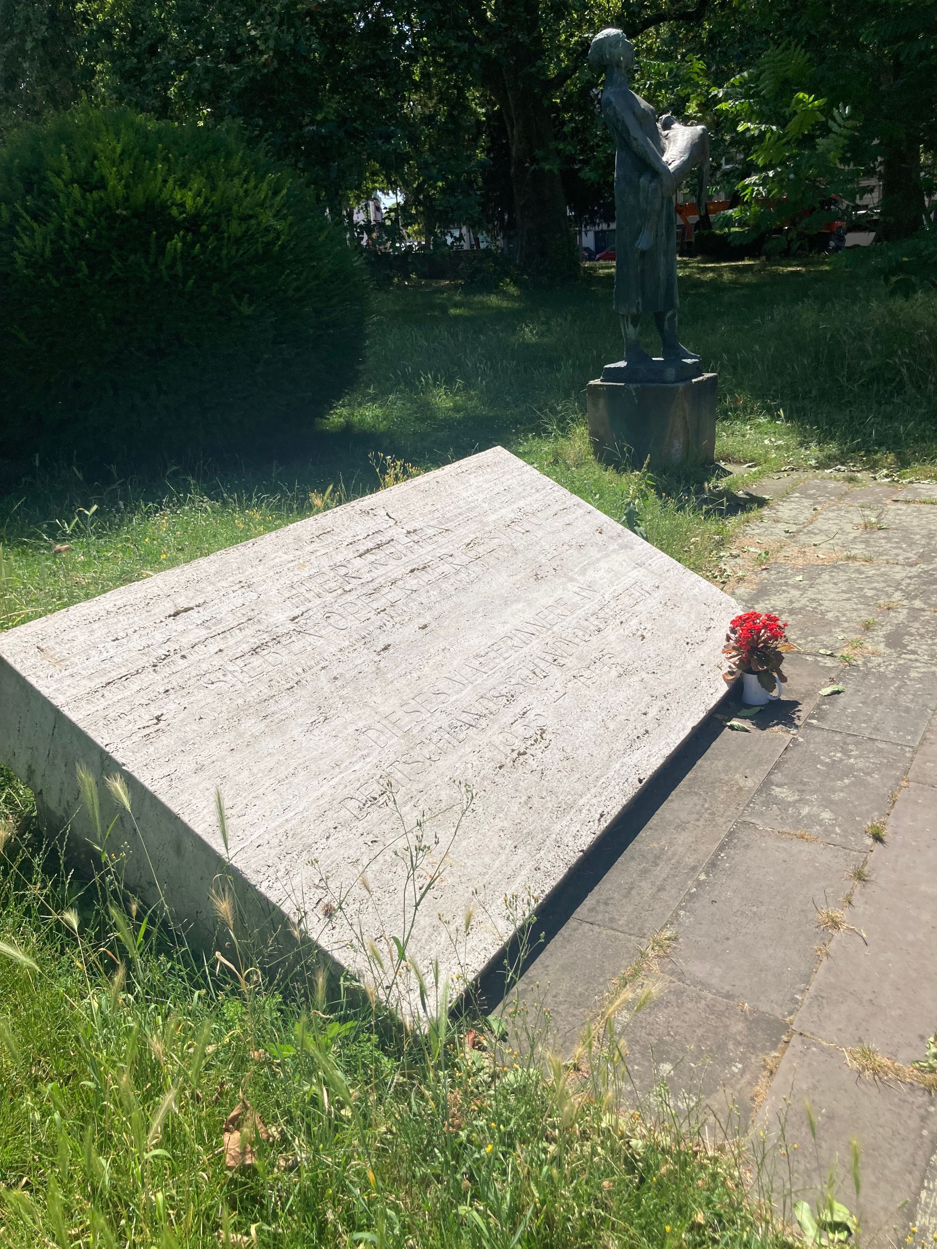 Das Bild zeigt eine Gedenktafel, deren Inschrift kaum zu lesen ist.