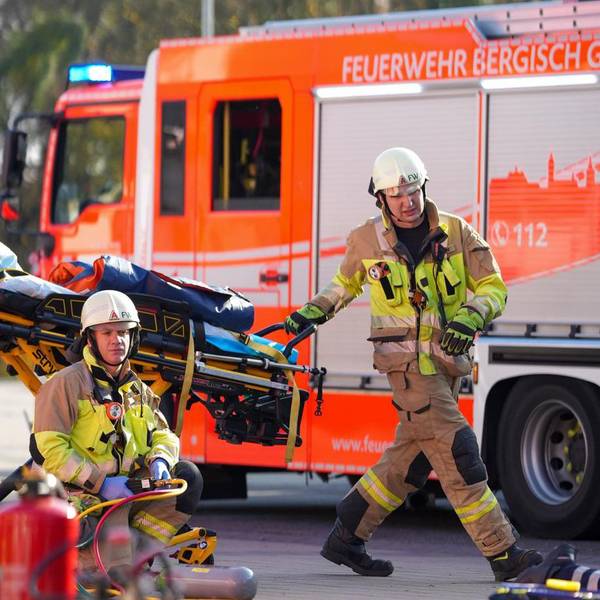 Ein Feuerwehrauto und zwei Feuerwehrmänner