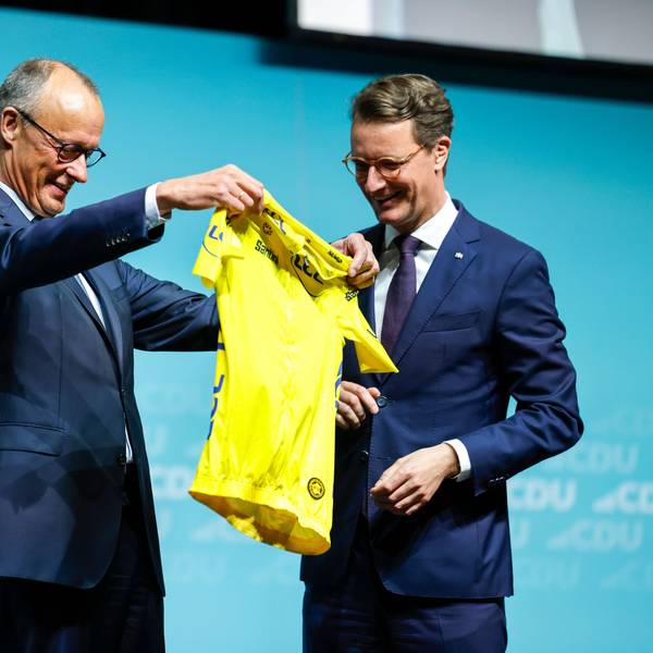 Hendrik Wüst (r,CDU), Ministerpräsident von Nordrhein-Westfalen, überreicht Bundeskanzler Friedrich Merz (CDU) beim Landesparteitag der CDU Nordrhein-Westfalen ein gelbes Rennradtrikot, dies ist das prestigeträchtigste Symbol bei der Tour de France. Es kennzeichnet den Führenden in der Gesamtwertung.