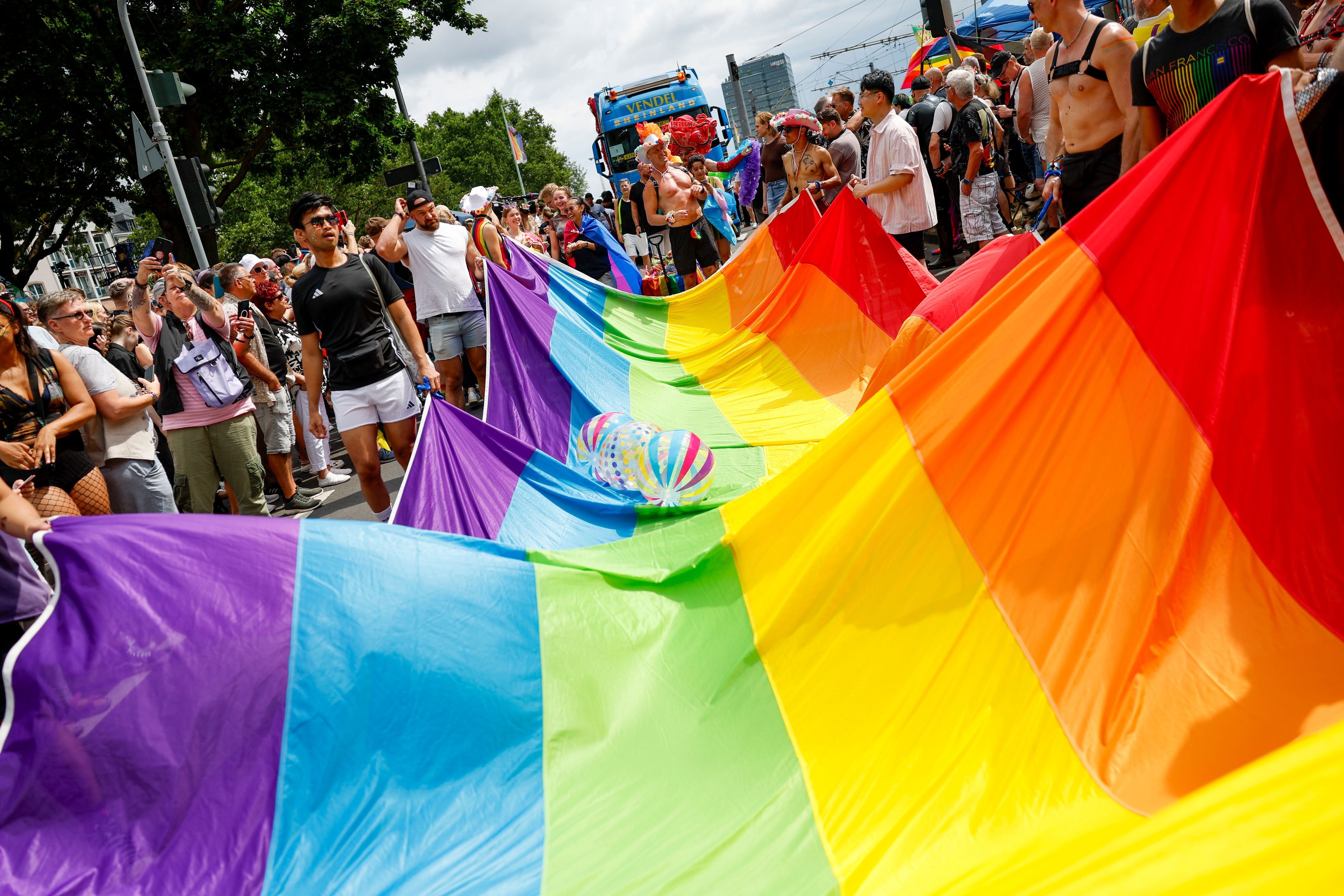05.07.2026, Nordrhein-Westfalen, Köln: Teilnehmer der Parade zum Christopher Street Day tragen eine überdimensionale Regenbogenfahne. Foto: Thomas Banneyer/dpa +++ dpa-Bildfunk +++