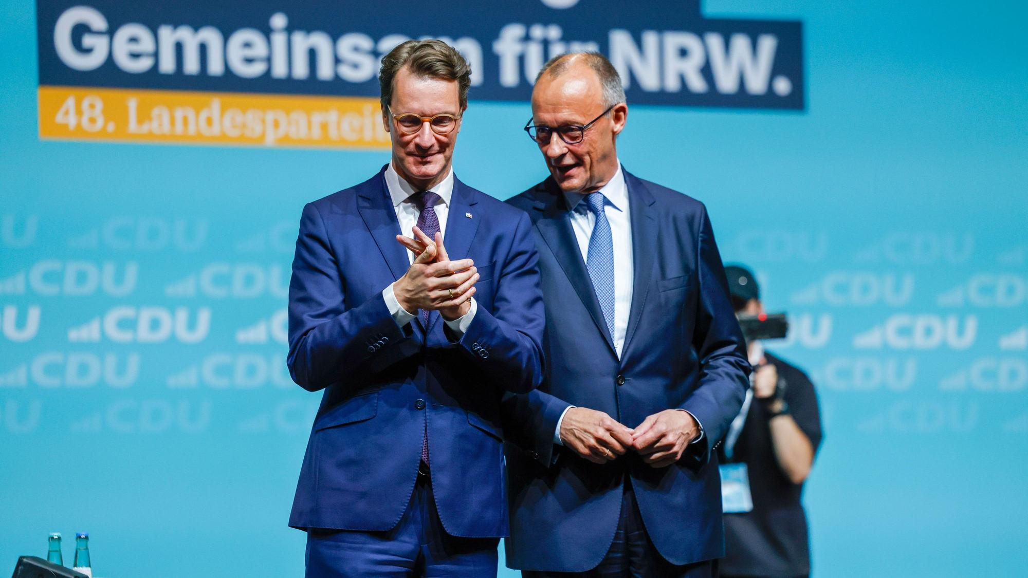 Bundeskanzler Friedrich Merz (r, CDU) steht beim Landesparteitag der CDU Nordrhein-Westfalen mit Hendrik Wüst (CDU), Ministerpräsident von Nordrhein-Westfalen, auf der Bühne.