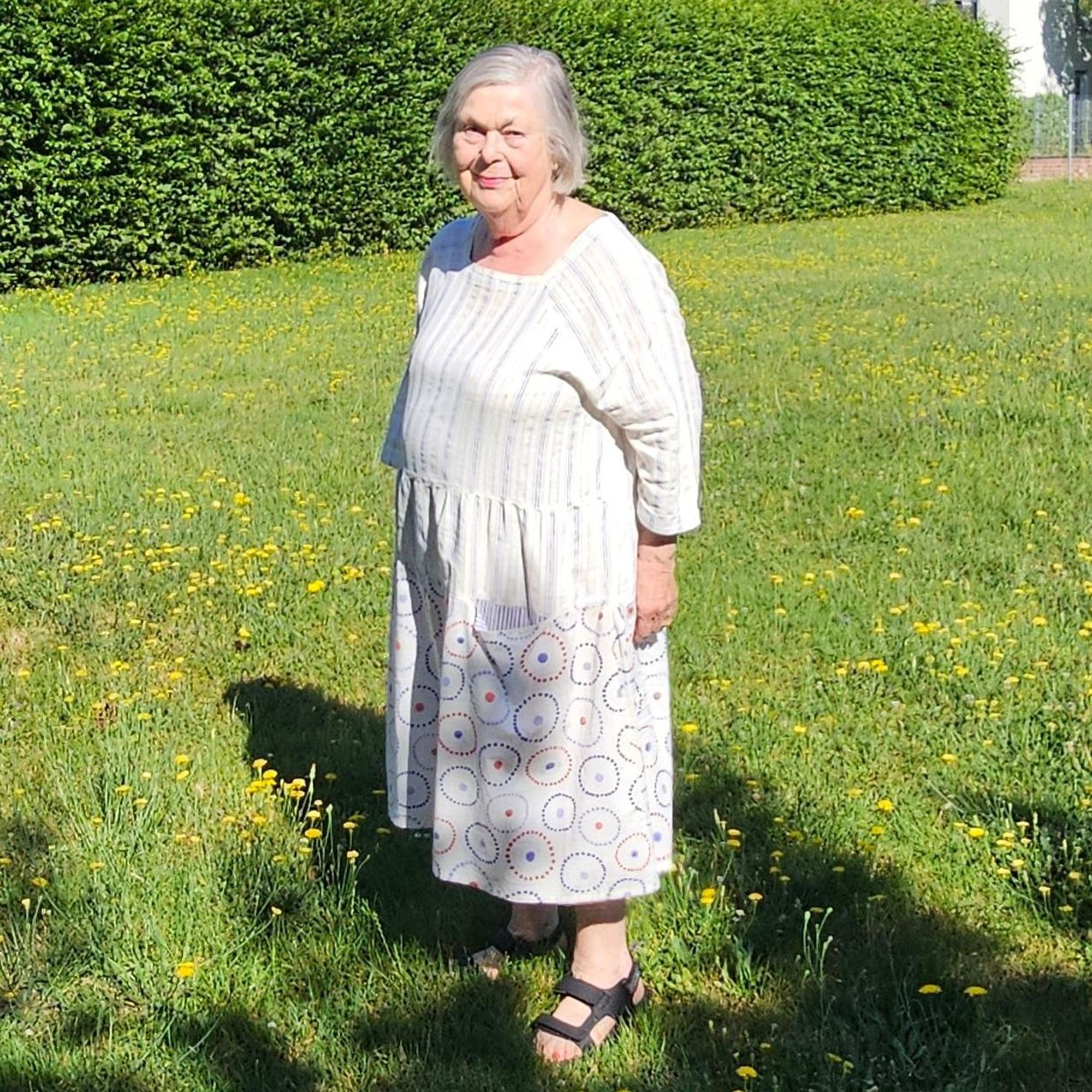 Eine Frau steht auf einer Wiese.
