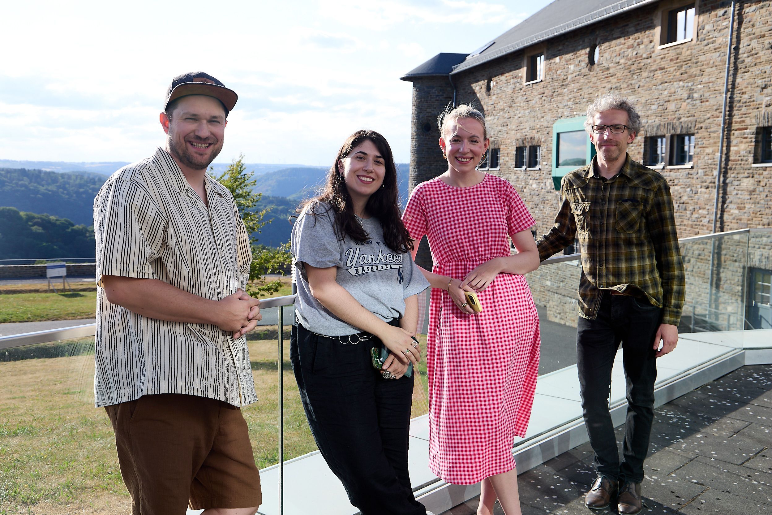 Julius Esser, Aylin Celik, Hannah Braucks und René Greschert stehen draußen an der Burg Vogelsang und lachen in die Kamera.