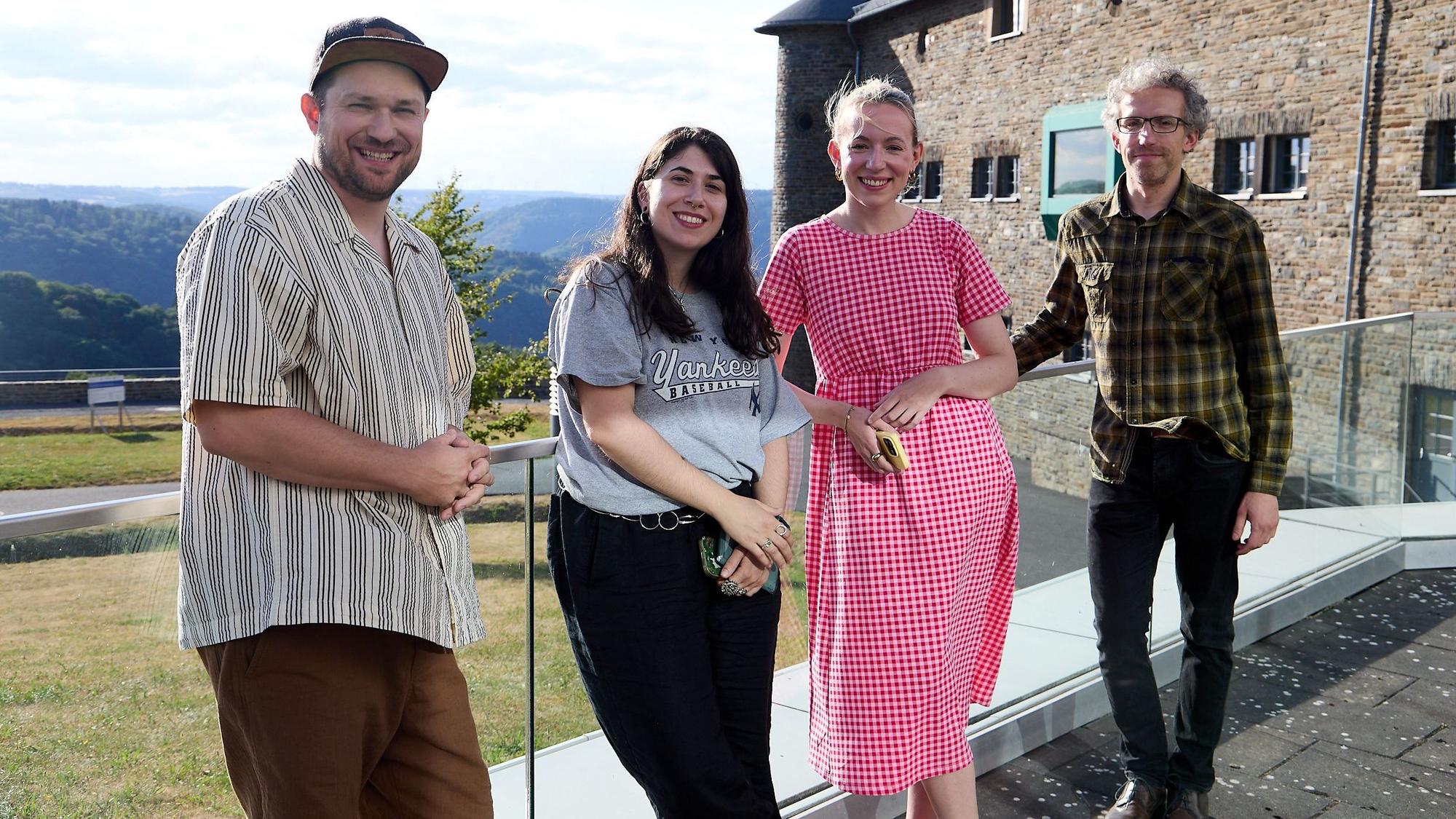 Julius Esser, Aylin Celik, Hannah Braucks und René Greschert stehen draußen an der Burg Vogelsang und lachen in die Kamera.