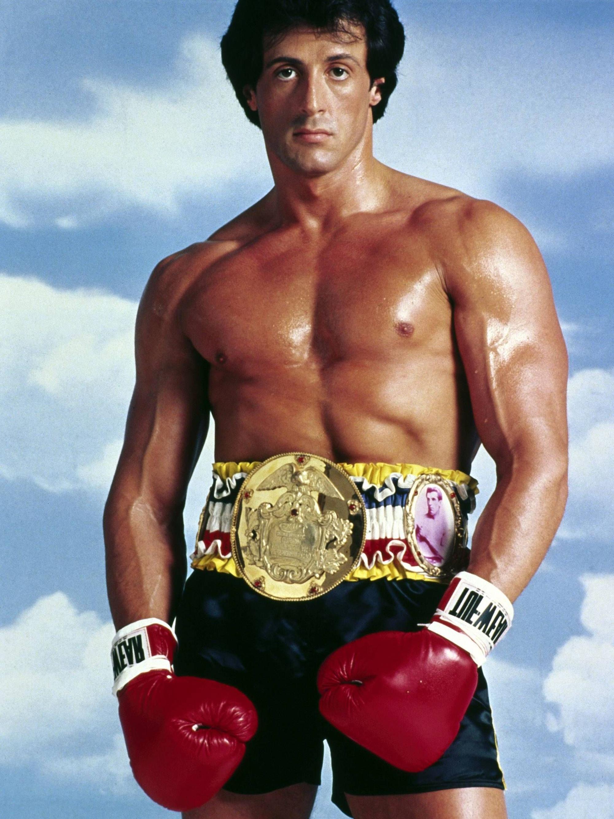 Sylvester Stallone trägt ein Boxkostüm und schaut in die Kamera.