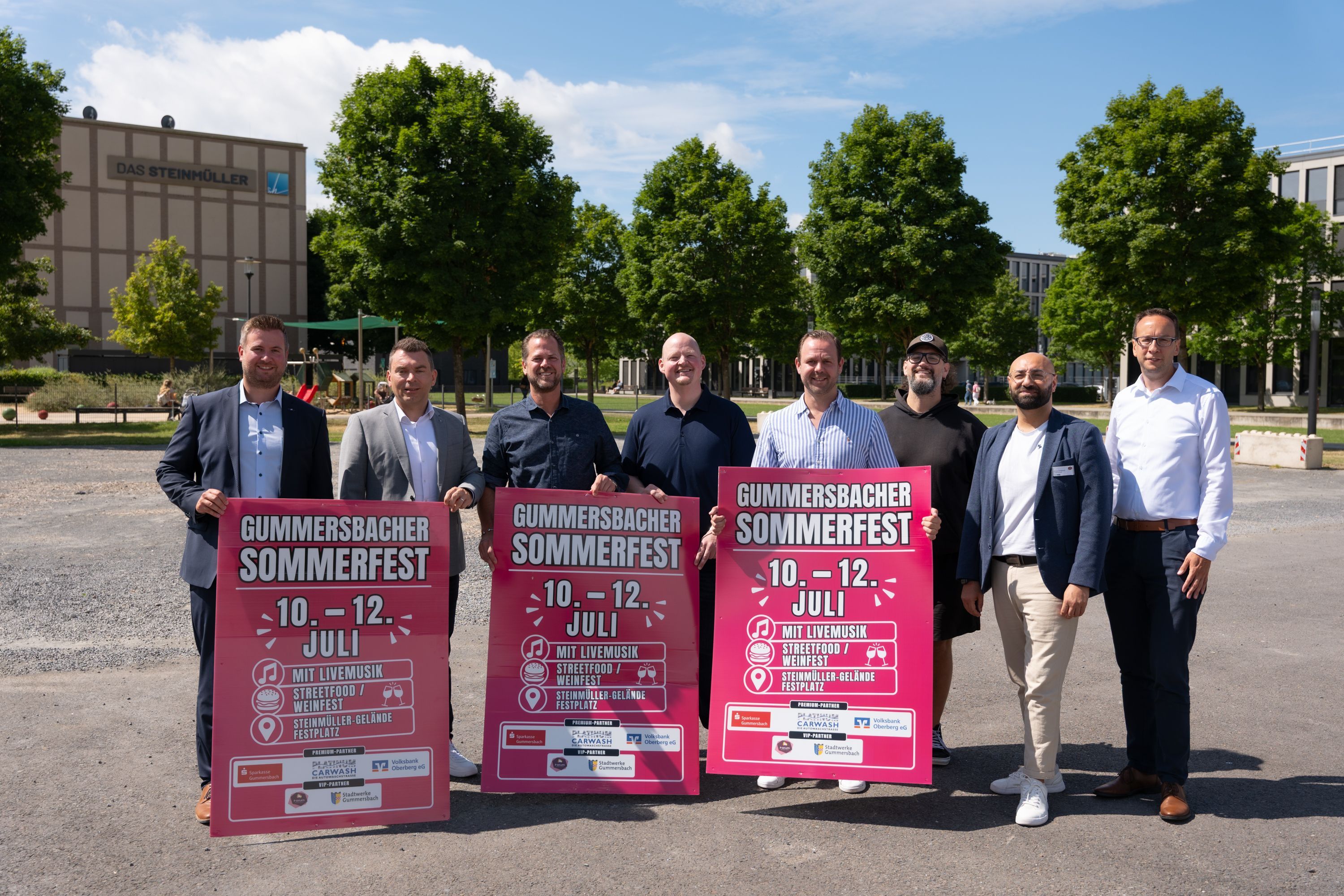 Mehrere Vertreter halten Schilder mit Werbung für das Gummersbacher Sommerfest in den Händen.