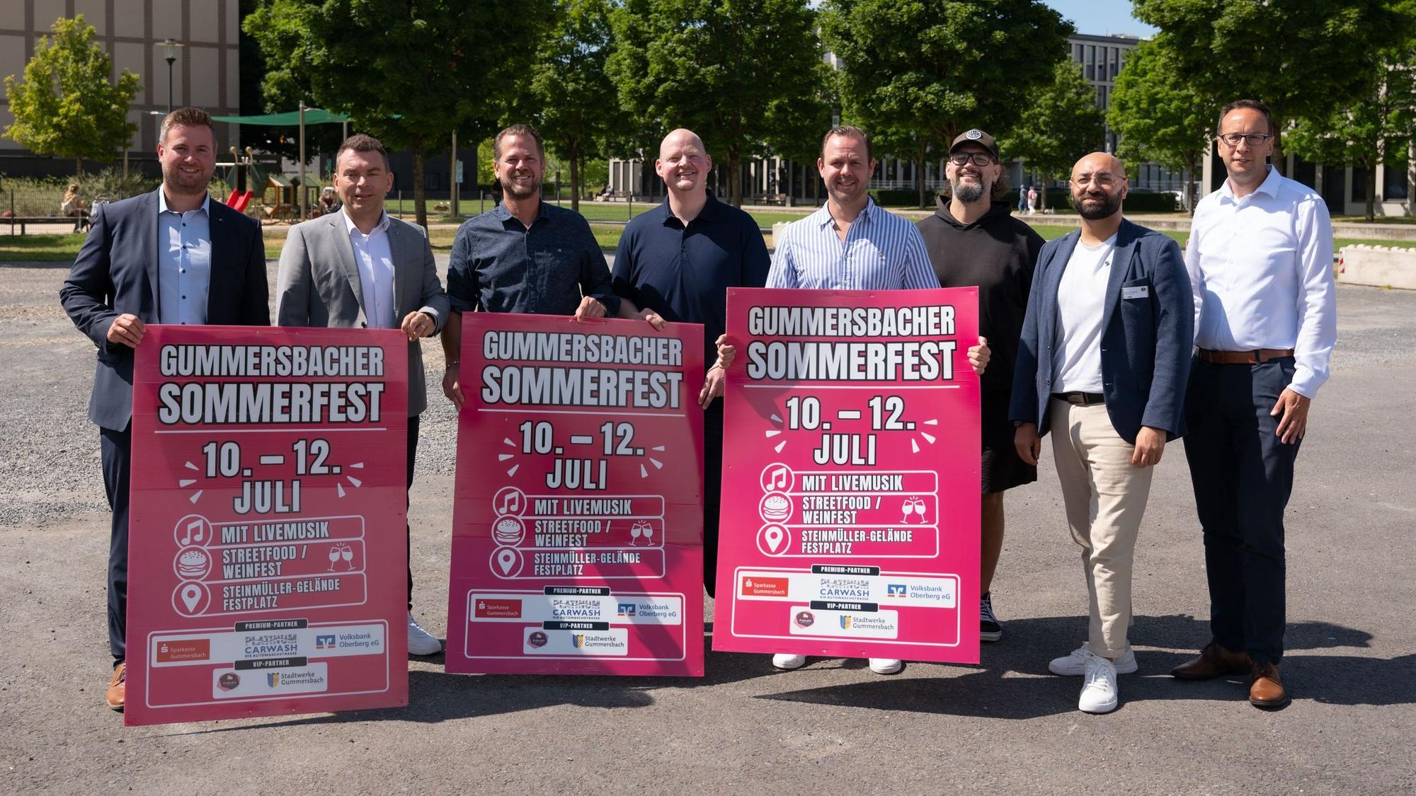 Mehrere Vertreter halten Schilder mit Werbung für das Gummersbacher Sommerfest in den Händen.