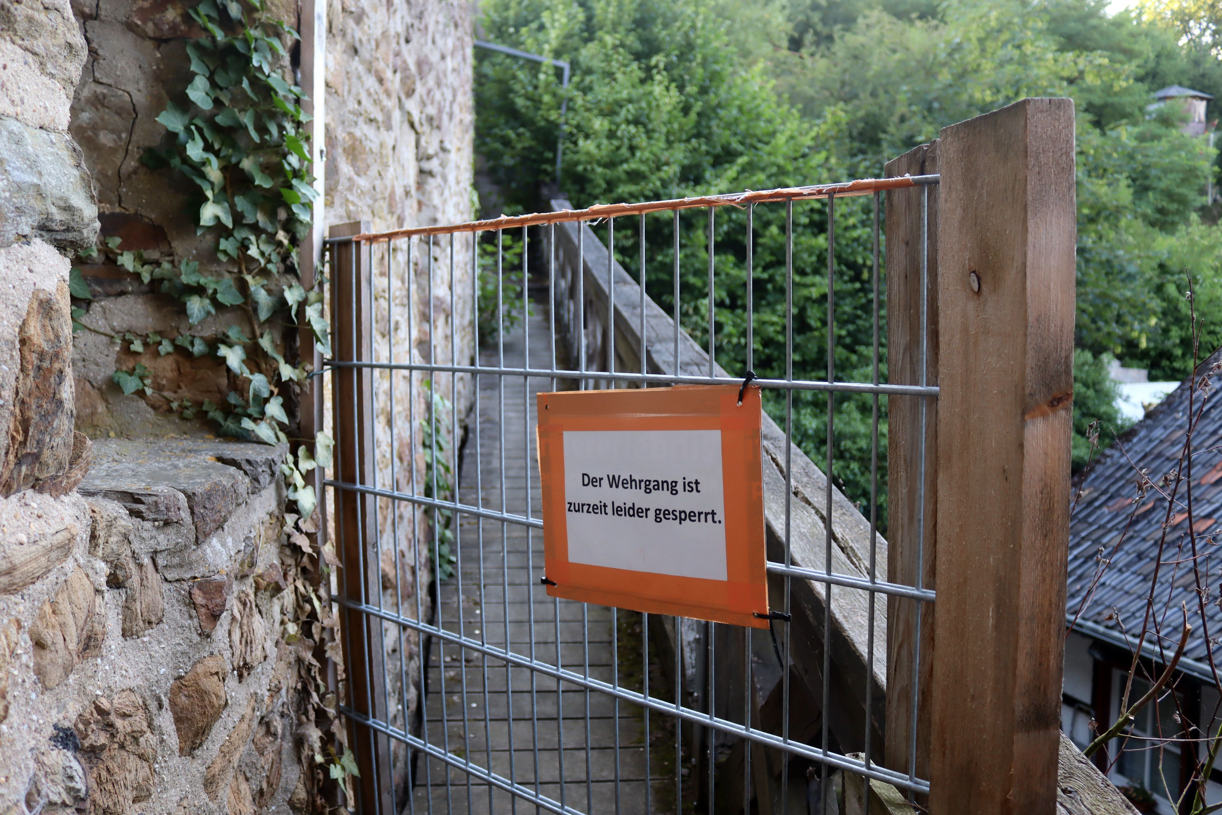 Ein Zaunelement versperrt den Wehrgang in Bad Münstereifel. Auf einem Schild steht „Der Wehrgang ist zurzeit leider gesperrt.“