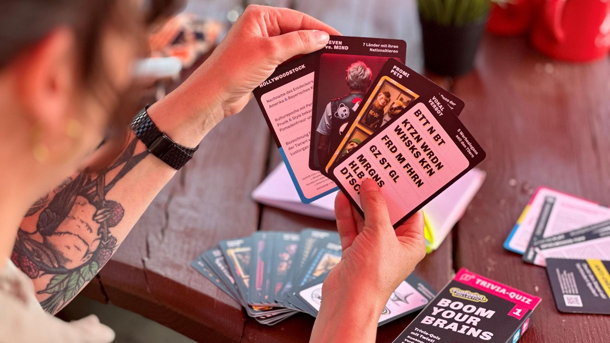 Eine Frau hält Spielkarten in einer Hand.