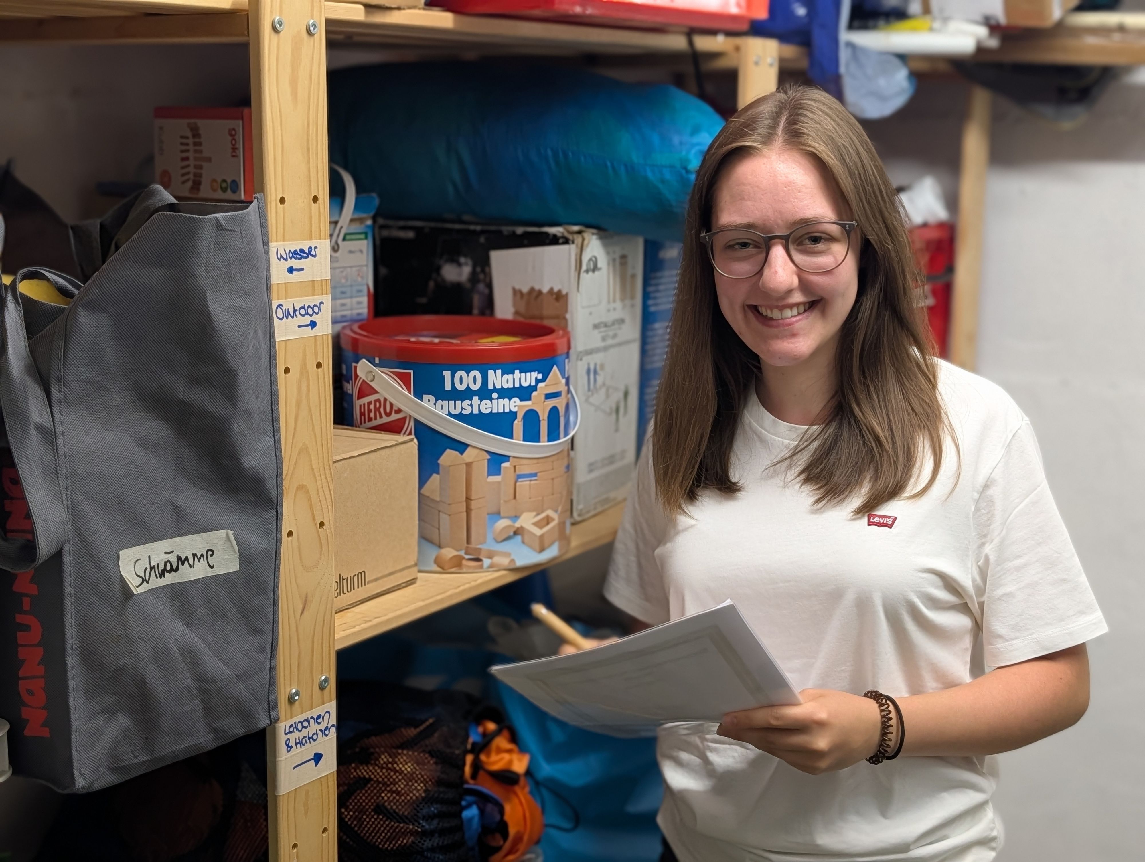 Das Foto zeigt Julia Krüger mit einer Inventarliste im Materialkeller.