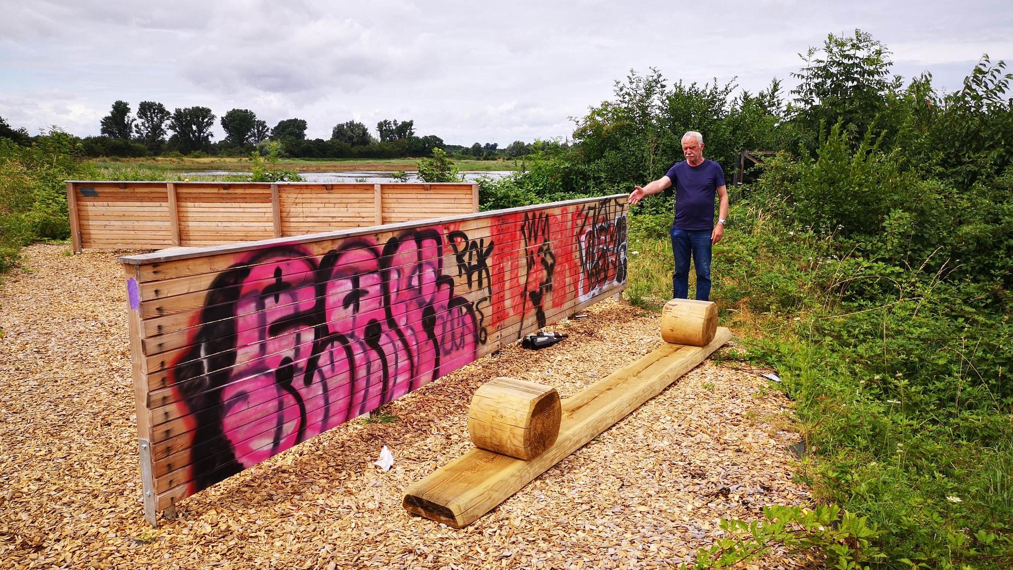 Das Foto zeigt den Naturschützer neben einer Schutzwand, die mit Graffiti beschmiert ist.