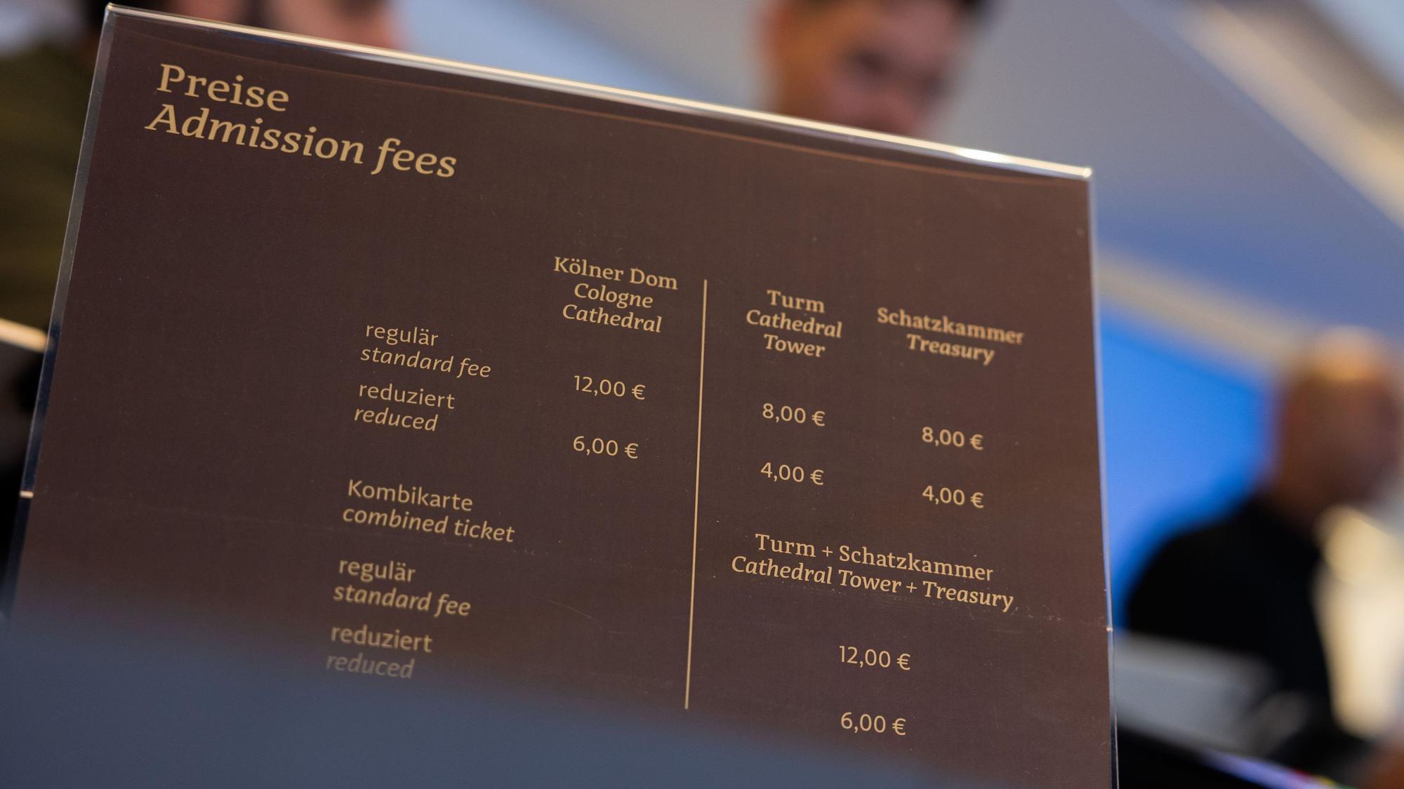 Eine Tafel im Ticketshop des Kölner Doms gibt Auskunft über die Preise für Dombesichtigung, Turmbesteigung und Schatzkammerbesuch.