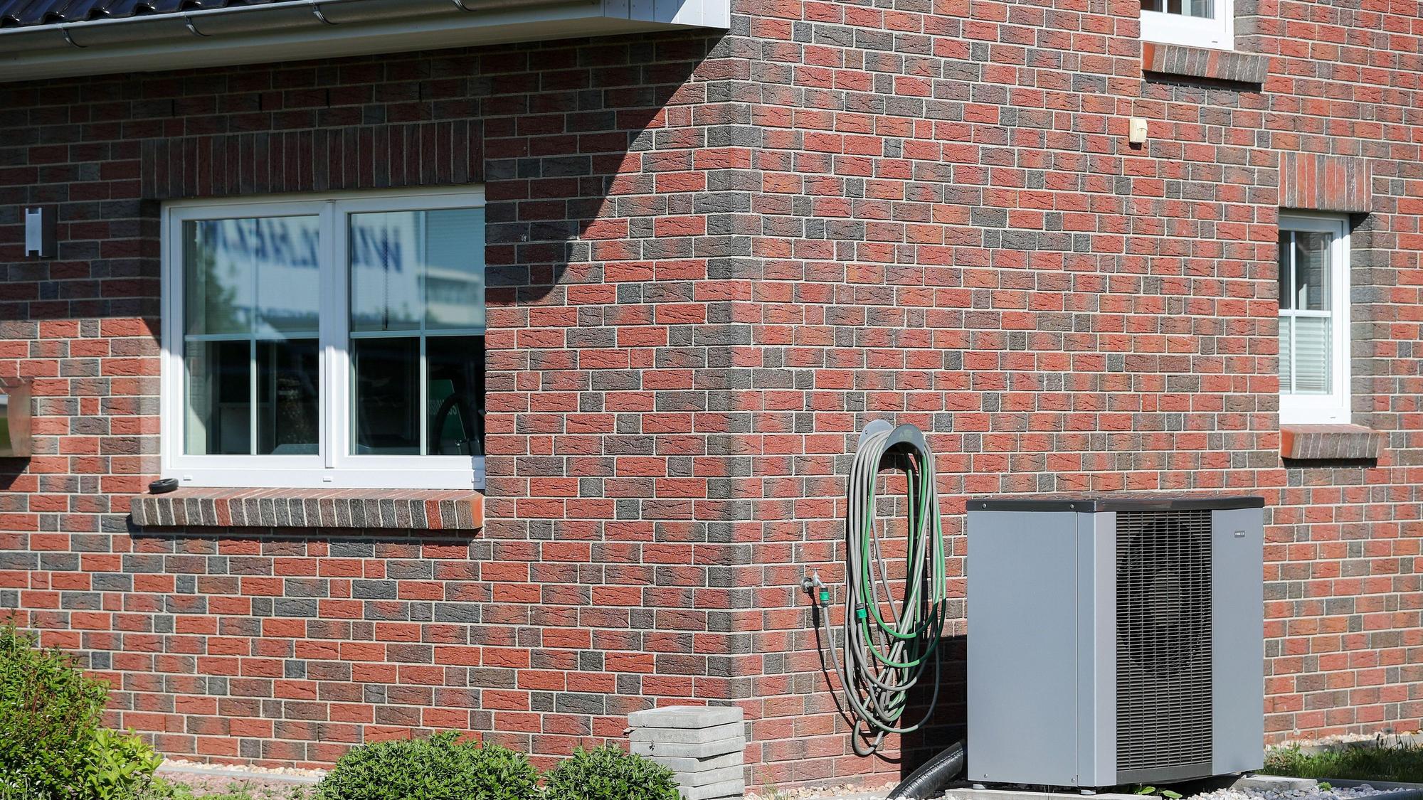 Eine Wärmepumpe steht vor einem Haus. Das Gerät kann zwar auch kühlen, trotzdem will die Regierung den Einbau weniger stark fördern. (Symbolbild)