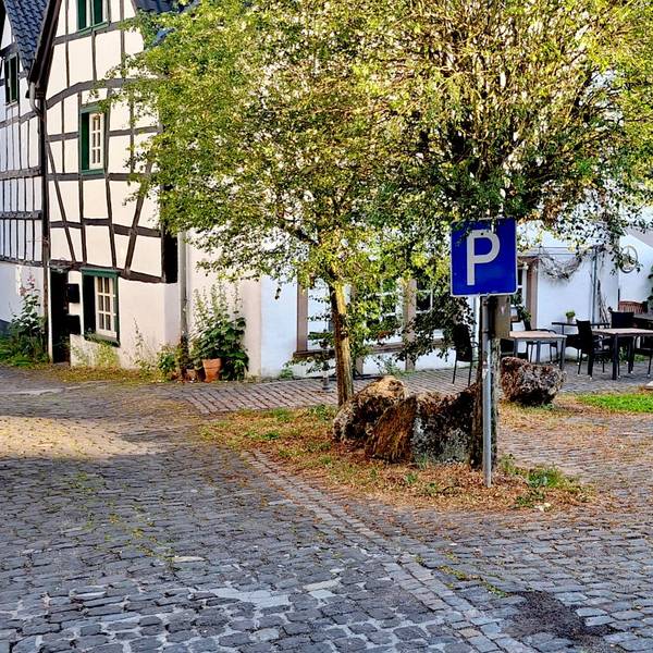 Das Pflaster des Parkplatzes ist uneben.