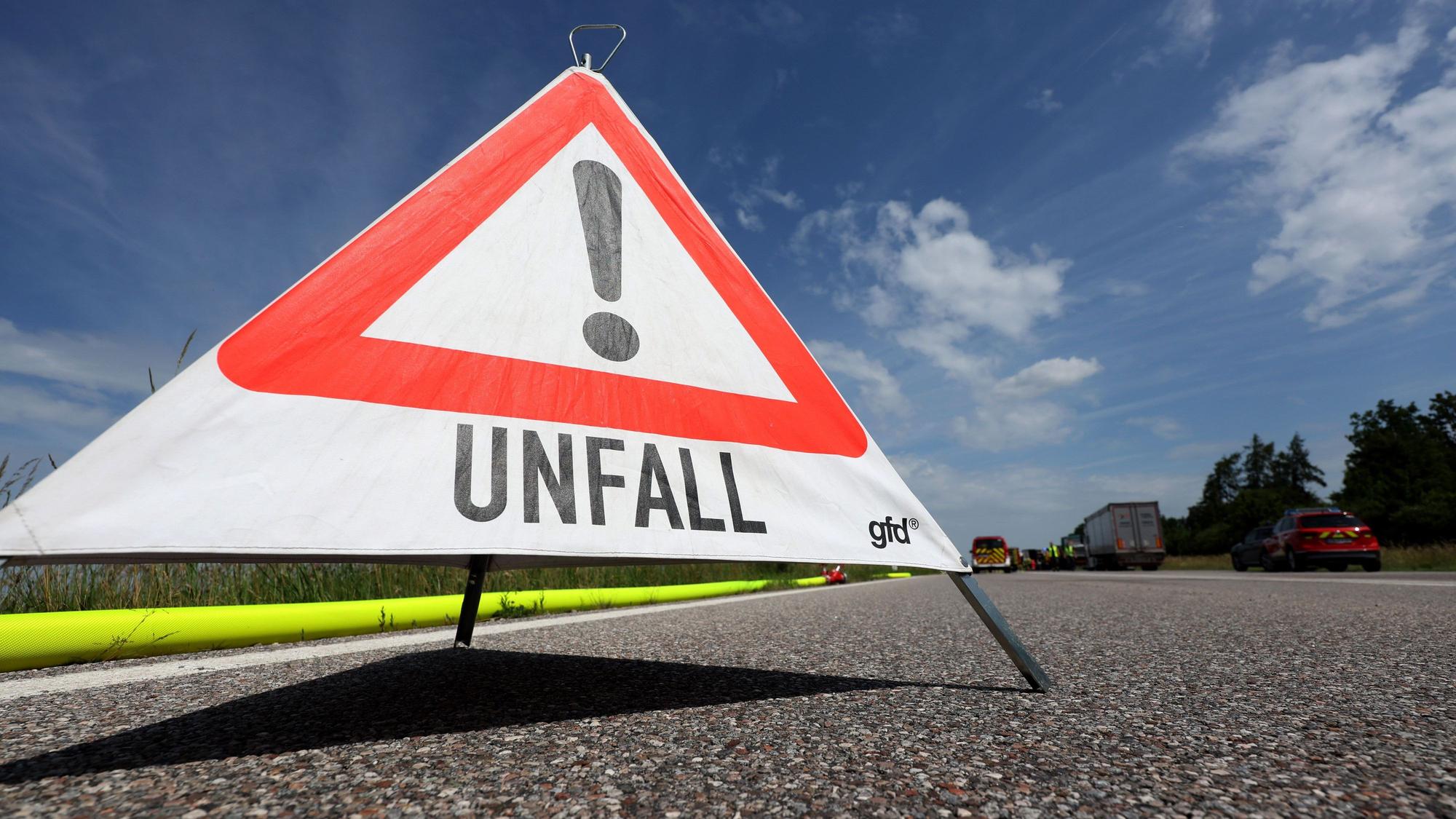 Ein Warndreieck mit der Aufschrift „Unfall“ steht auf einer Autobahn. (Symbolbild)