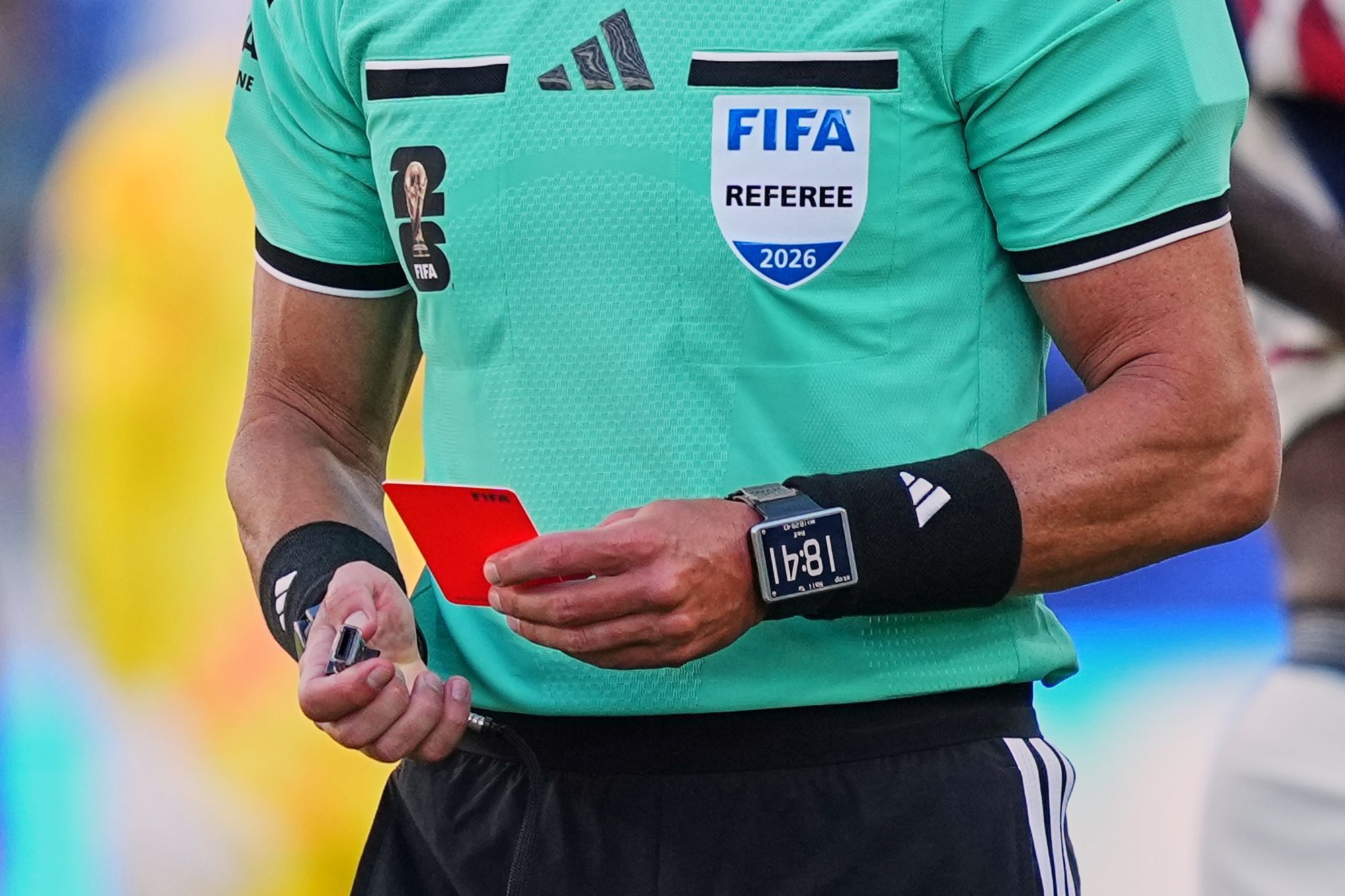 Ein Schiedsrichter der Fifa hält eine Rote Karte in der linken Hand.