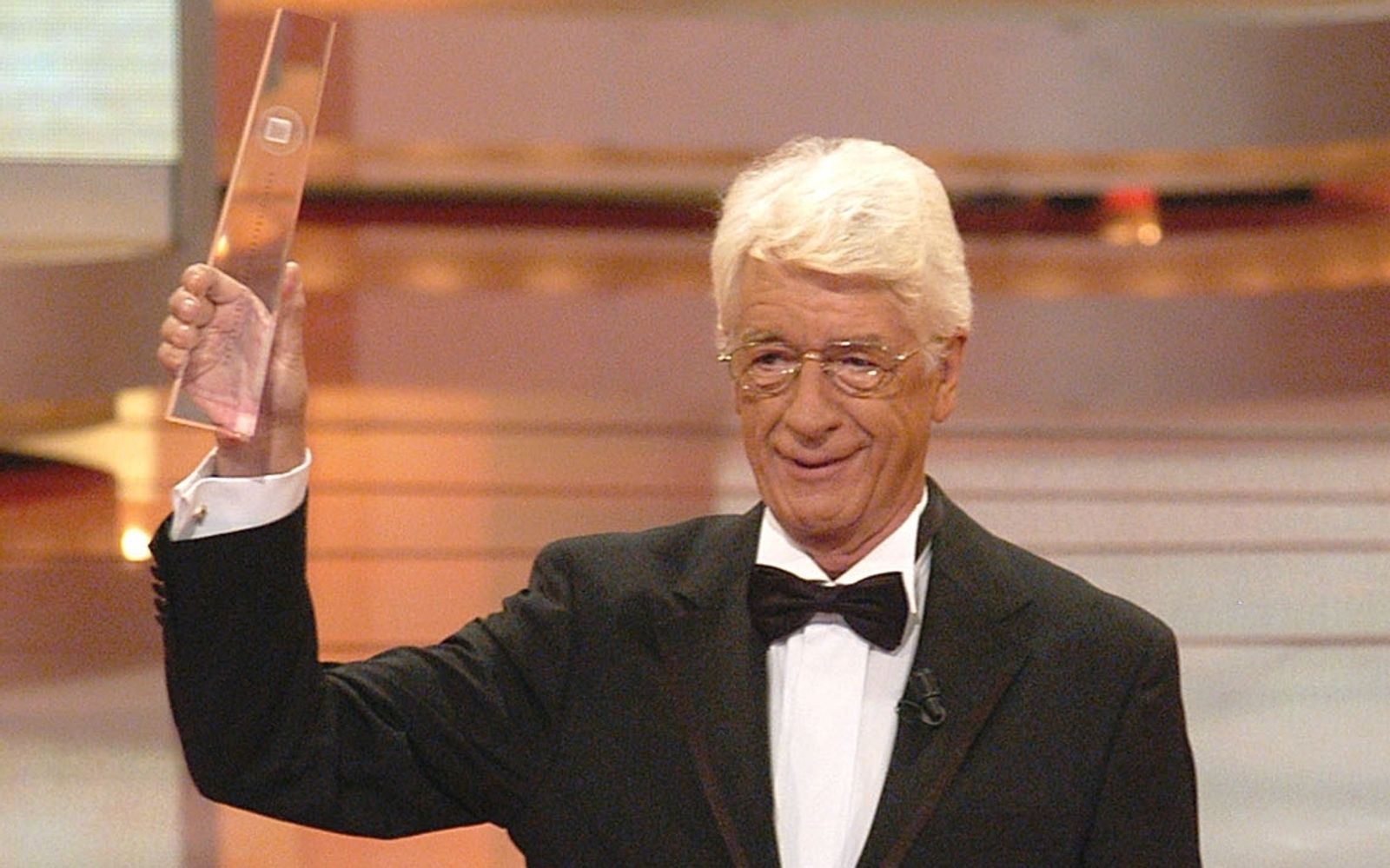 Mit Sendungen wie „Am laufenden Band“ schrieb Rudi Carrell Fernsehgeschichte. Hier hält Rudi Carrell den „Deutschen Fernsehpreis 2003“ in der Sparte „Ehrenpreis der Stifter“ in Händen - einer von vielen unvergesslichen TV-Momenten mit Rudi Carrell. (Bild: WDR / Herby Sachs)