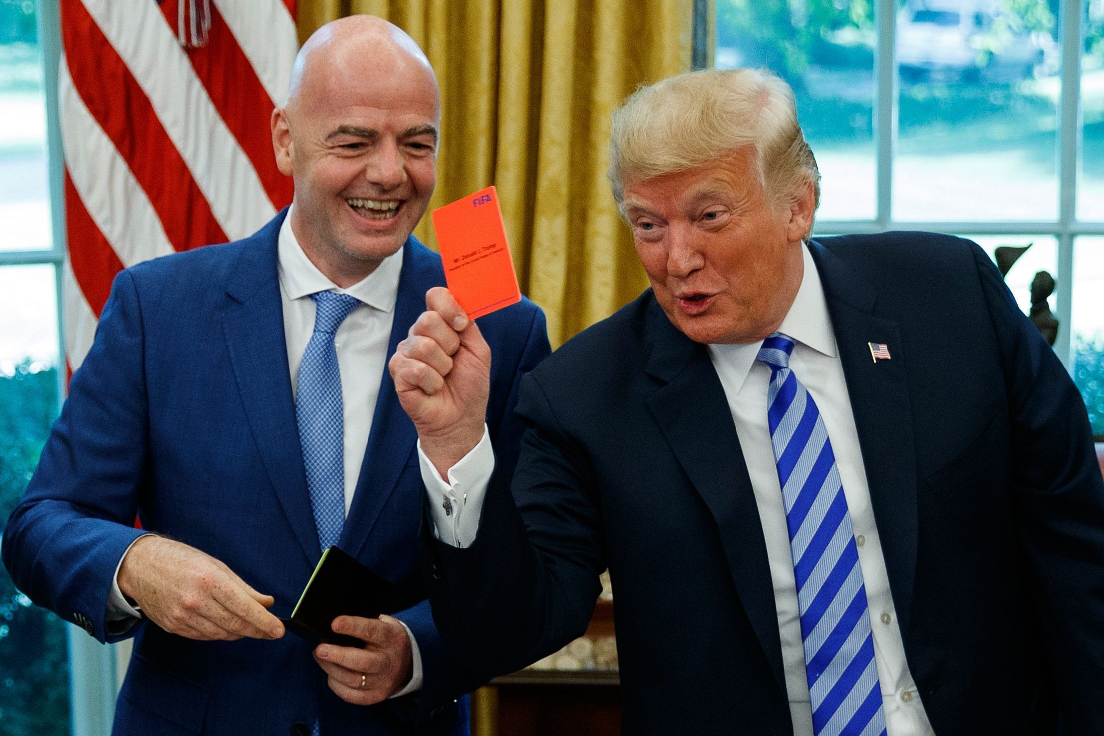 ARCHIV - 28.08.2018, USA, Washington: US-Präsident Donald Trump (r) hält während eines Treffens mit FIFA-Präsident Gianni Infantino im Oval Office des Weißen Hauses am 28.08.2018 eine rote Karte hoch. (zu dpa-Korr: «Anruf von Trump? Empörung nach FIFA-Kehrtwende bei US-Profi») Foto: Evan Vucci/AP/dpa +++ dpa-Bildfunk +++