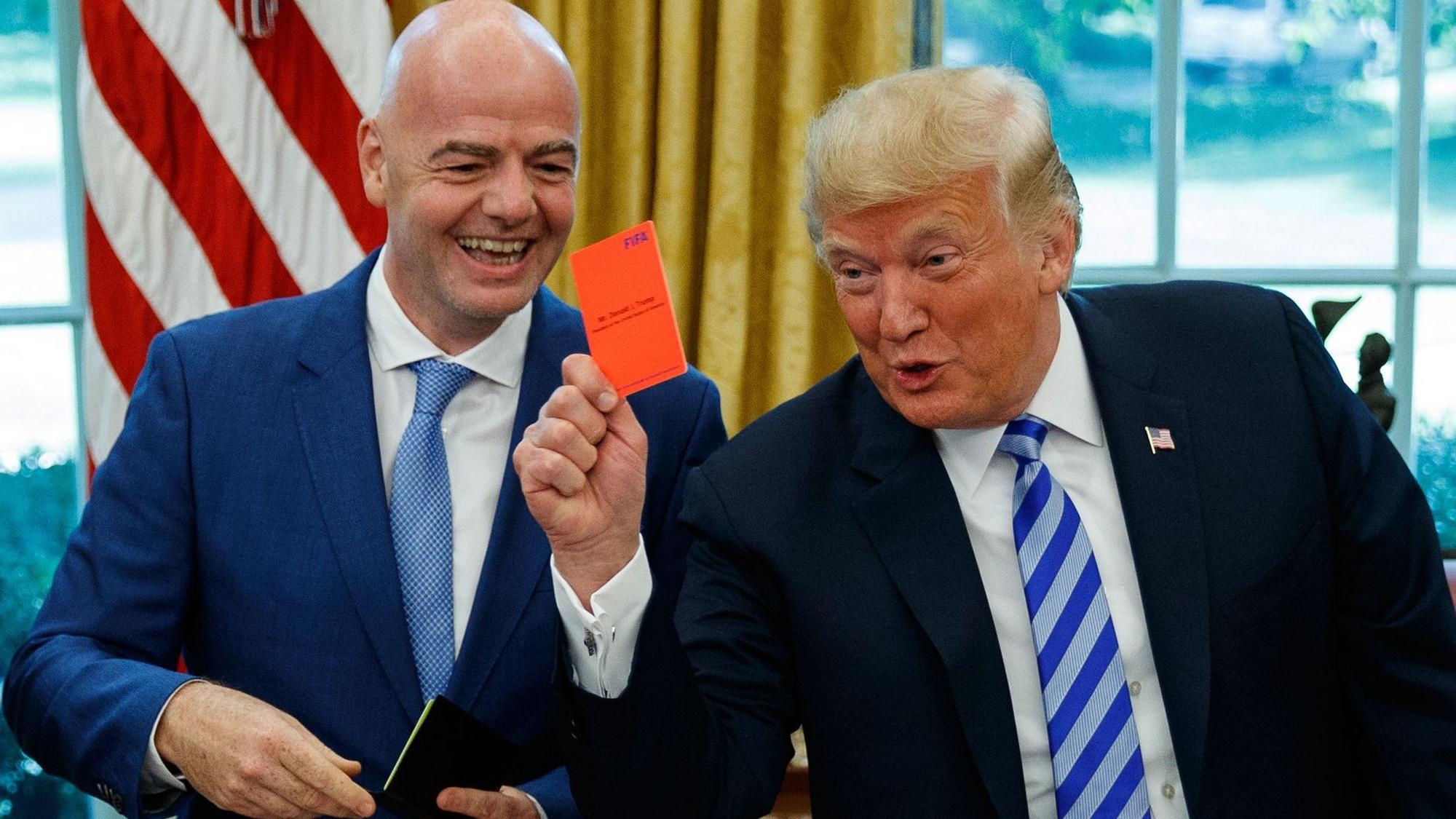 ARCHIV - 28.08.2018, USA, Washington: US-Präsident Donald Trump (r) hält während eines Treffens mit FIFA-Präsident Gianni Infantino im Oval Office des Weißen Hauses am 28.08.2018 eine rote Karte hoch. (zu dpa-Korr: «Anruf von Trump? Empörung nach FIFA-Kehrtwende bei US-Profi») Foto: Evan Vucci/AP/dpa +++ dpa-Bildfunk +++