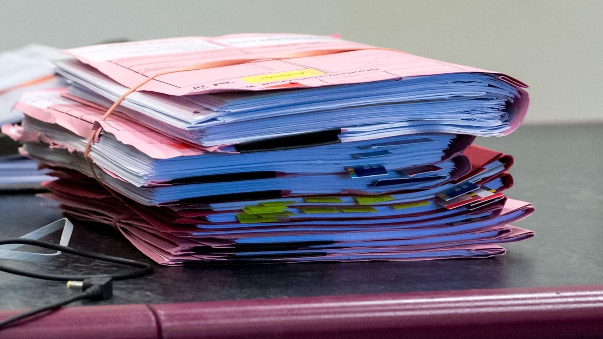 Prozessakten liegen im Landgericht auf dem Tisch des Gerichts.