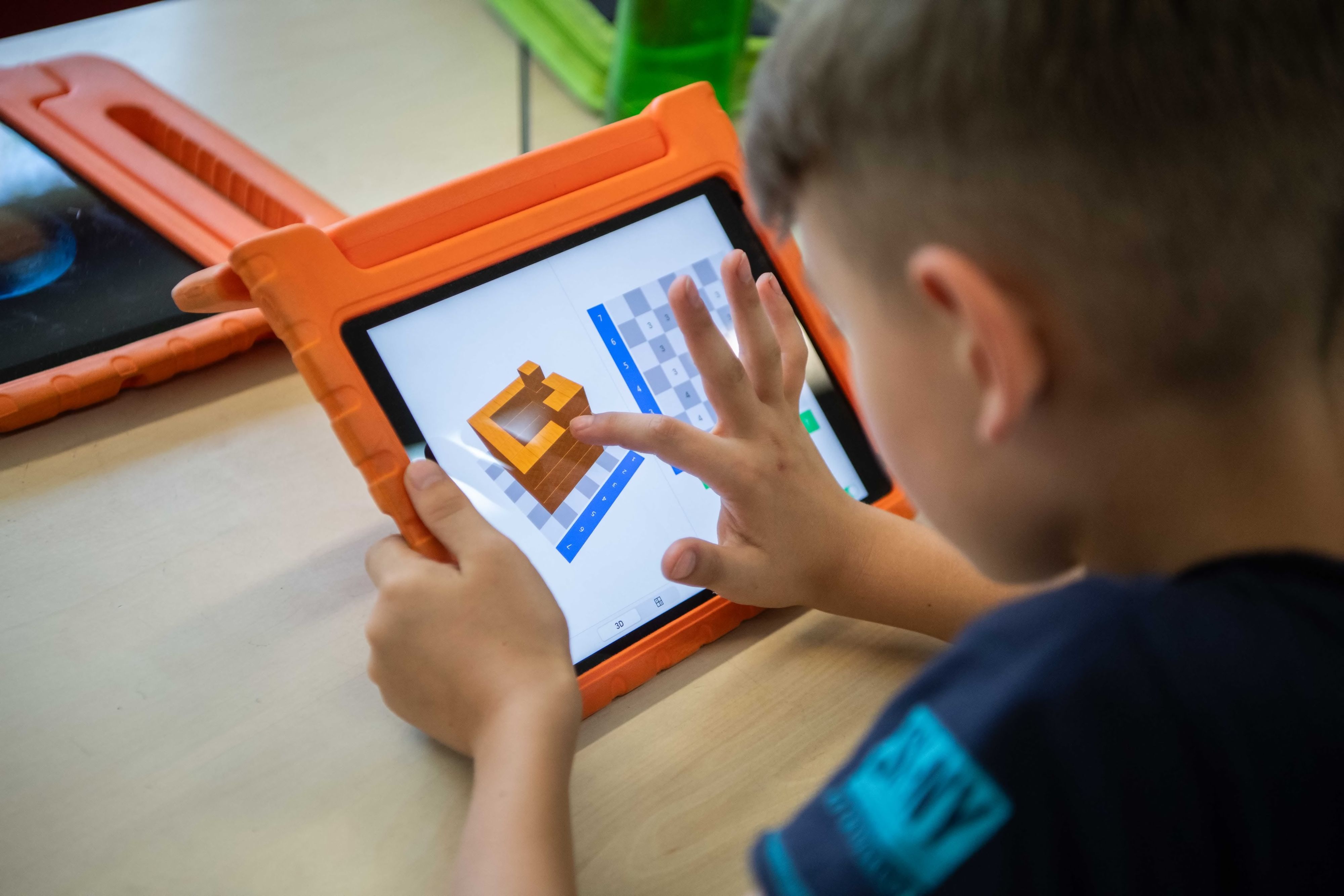 Das Bild zeigt einen Grundschüler, der an einem Tablet arbeitet.