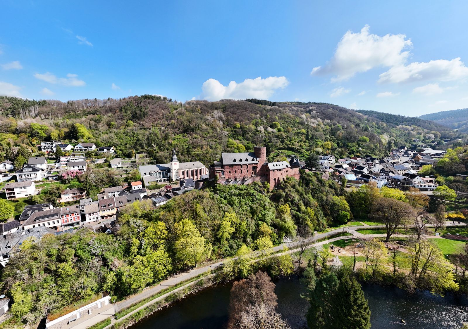 Ein Luftbild zeigt Grünanlagen und Gebäude.