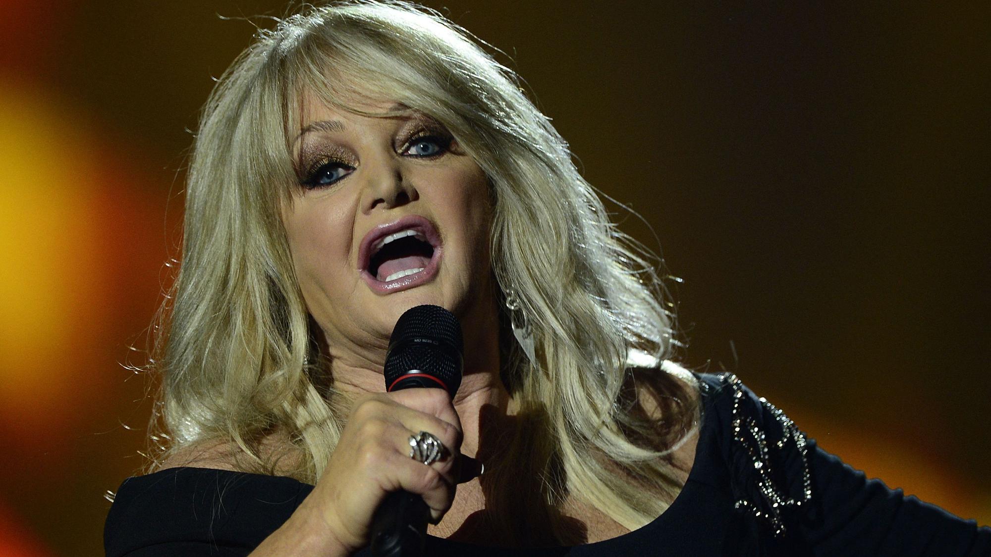 Bonnie Tyler singt in ein Mikro.