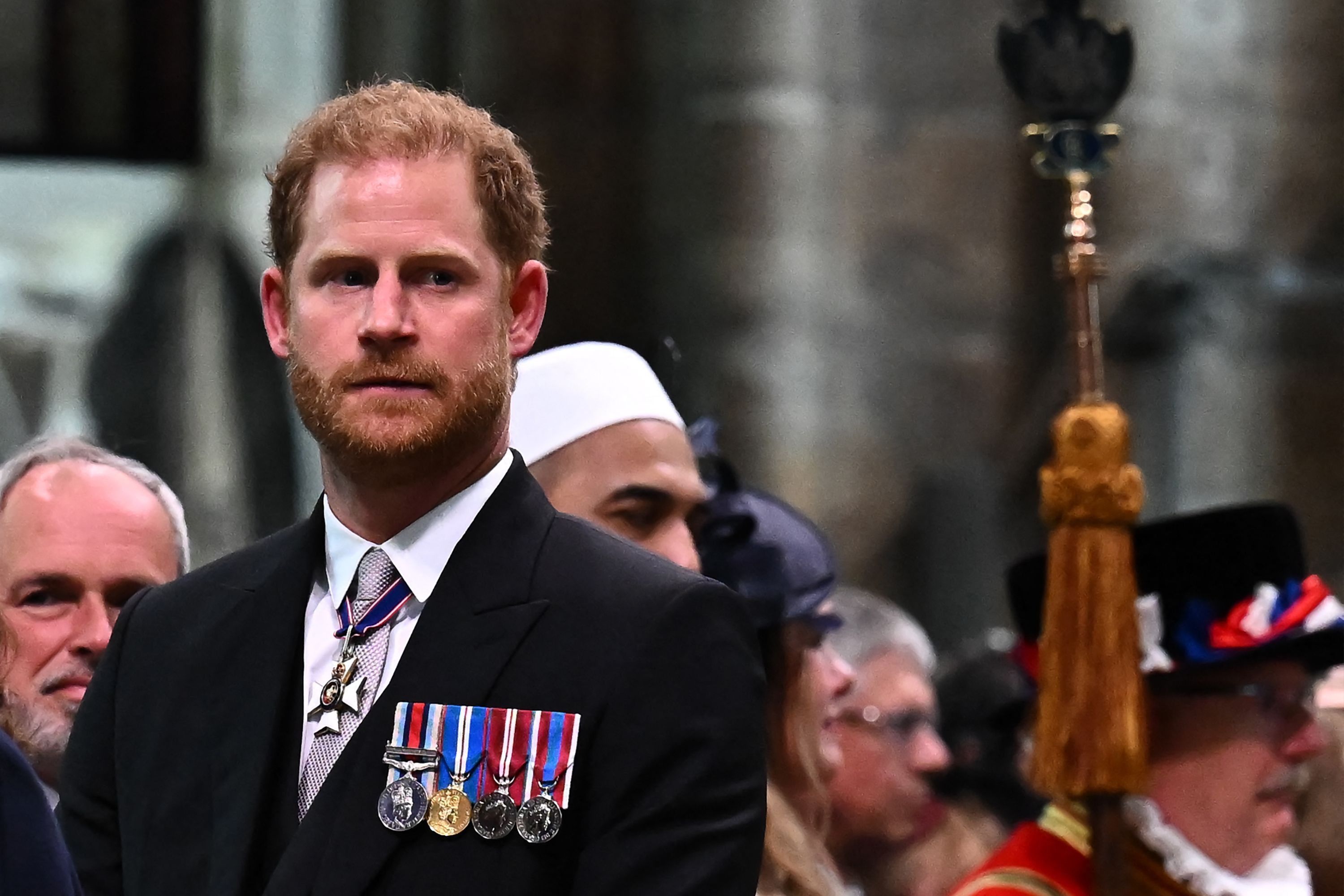 Prinz Harry in einem Anzug mit Medaillen.