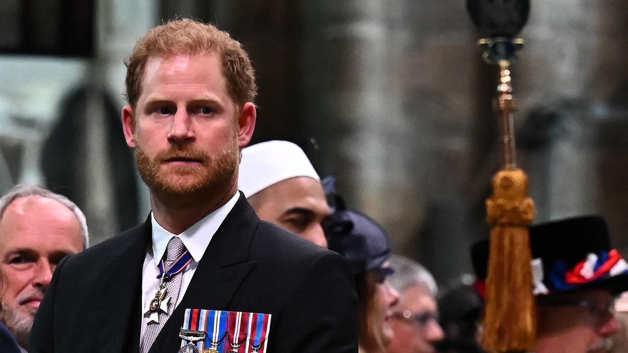 Prinz Harry in einem Anzug mit Medaillen.