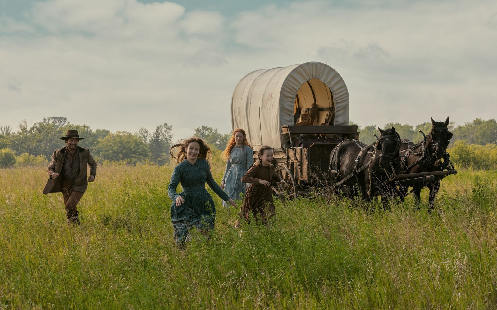 Fans der früheren Serie dürfte dieses Bild bekannt vorkommen, erinnert es doch an deren Vor- und Abspann. Auch im Reboot freuen sich Charles Ingalls (Luke Bracey), Mary (Skywalker Hughes), Caroline (Crosby Fitzgerald) und Laura (Alice Halsey) in Kansas auf einen Neuanfang.  (Bild: Eric Zachanowich/Netflix © 2026)