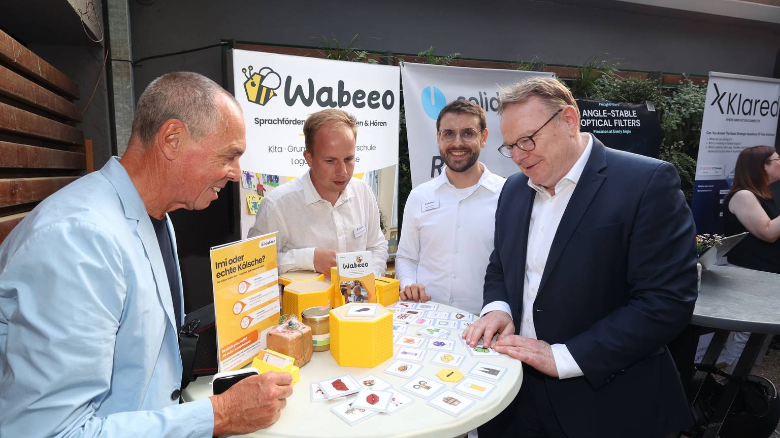 OB Torsten Burmester (r.) und Joachim Vranken von Web de Cologne (l.) lassen sich die Sprachlernbox des Kölner Start-ups Wabeeo zeigen. Entwickelt haben sie die Gründer Johannes Arnz und Simon Aschemeier.