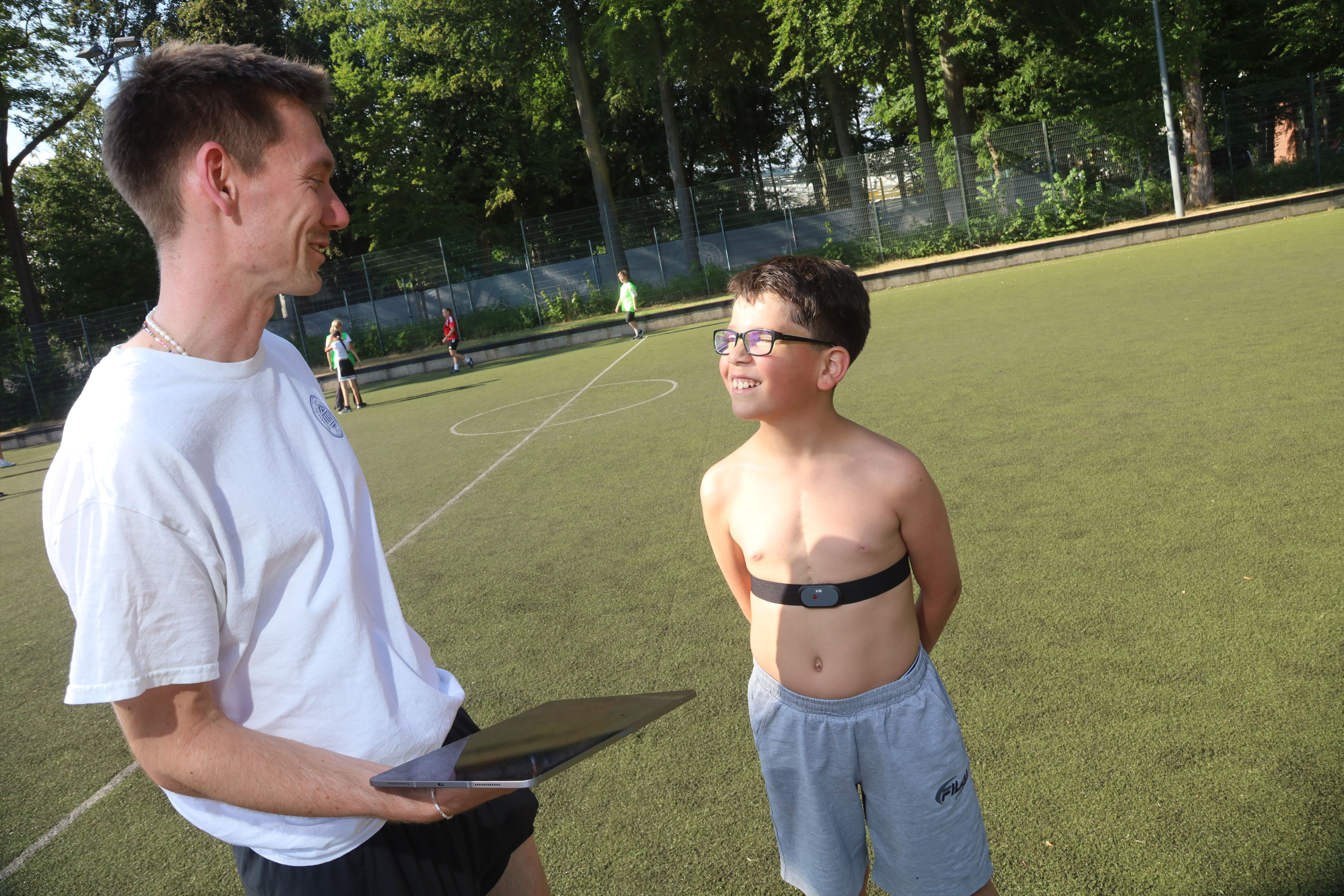 Doktorand Friedrich Schick von der Sporthochschule stattet Arian mit einem Pulsgurt aus. Der Zehnjährige lebt mit einem Einkammerherz.