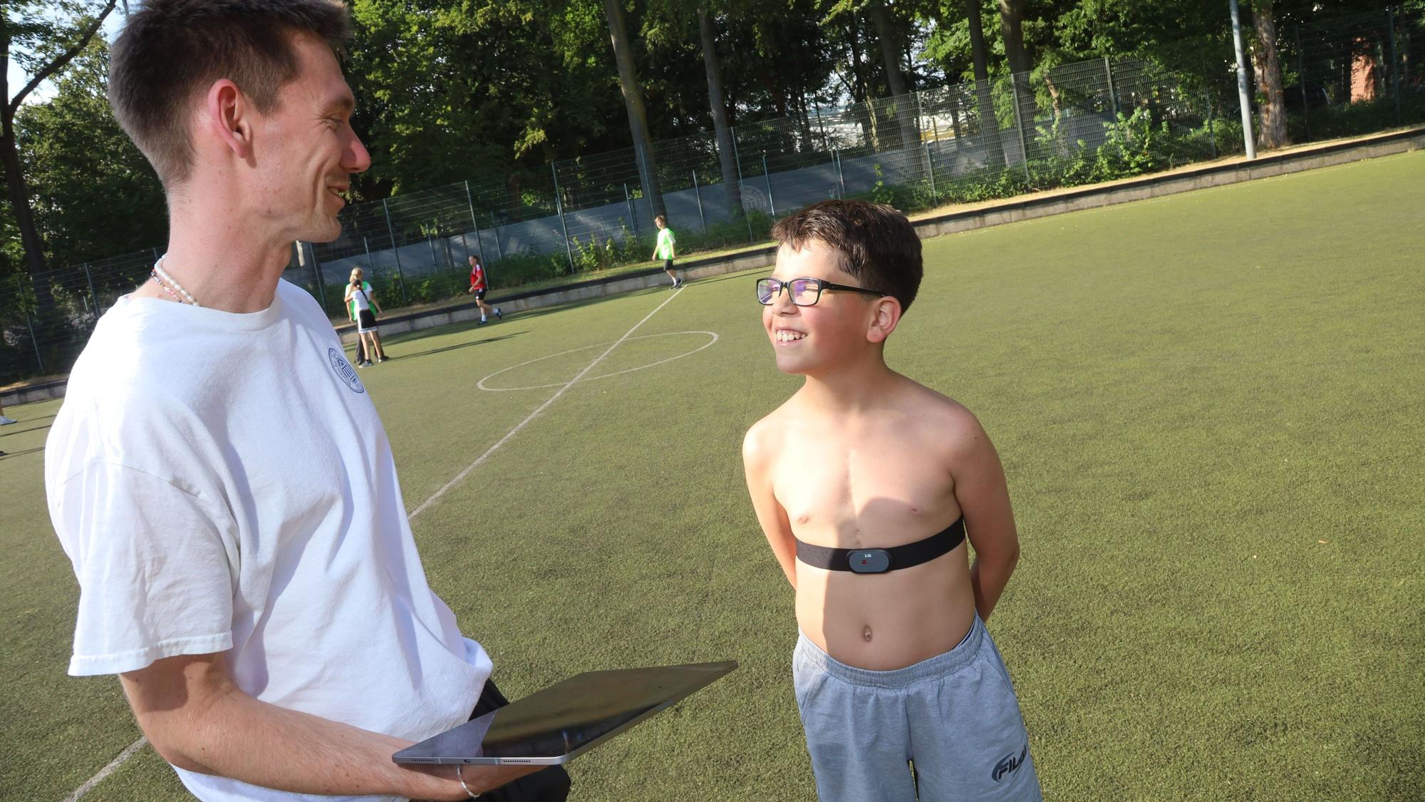 Doktorand Friedrich Schick von der Sporthochschule stattet Arian mit einem Pulsgurt aus. Der Zehnjährige lebt mit einem Einkammerherz.