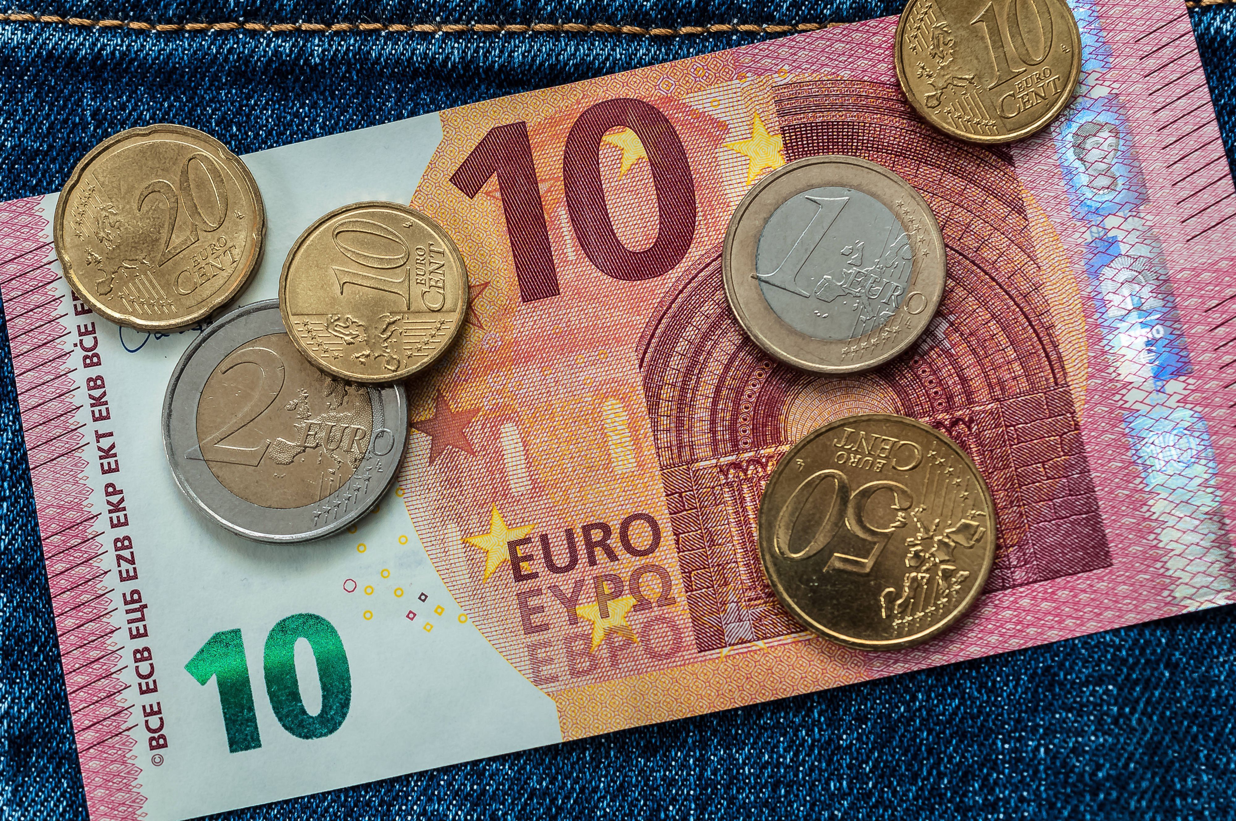 Detailaufnahme eines 10-Euro-Scheins mit Münzen (Symbolbild)